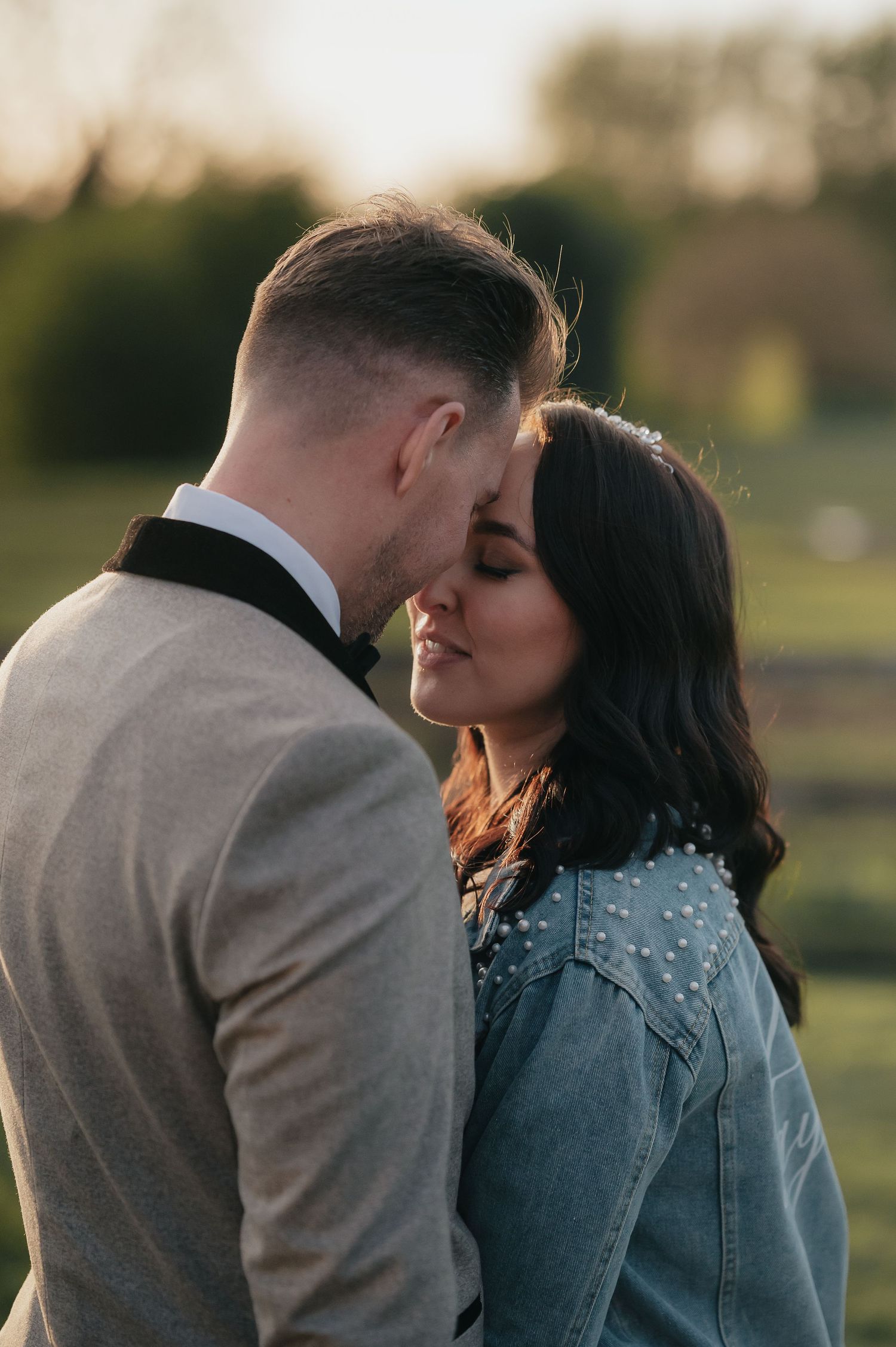 A tender sunset moment between a couple in formal wear and denim.