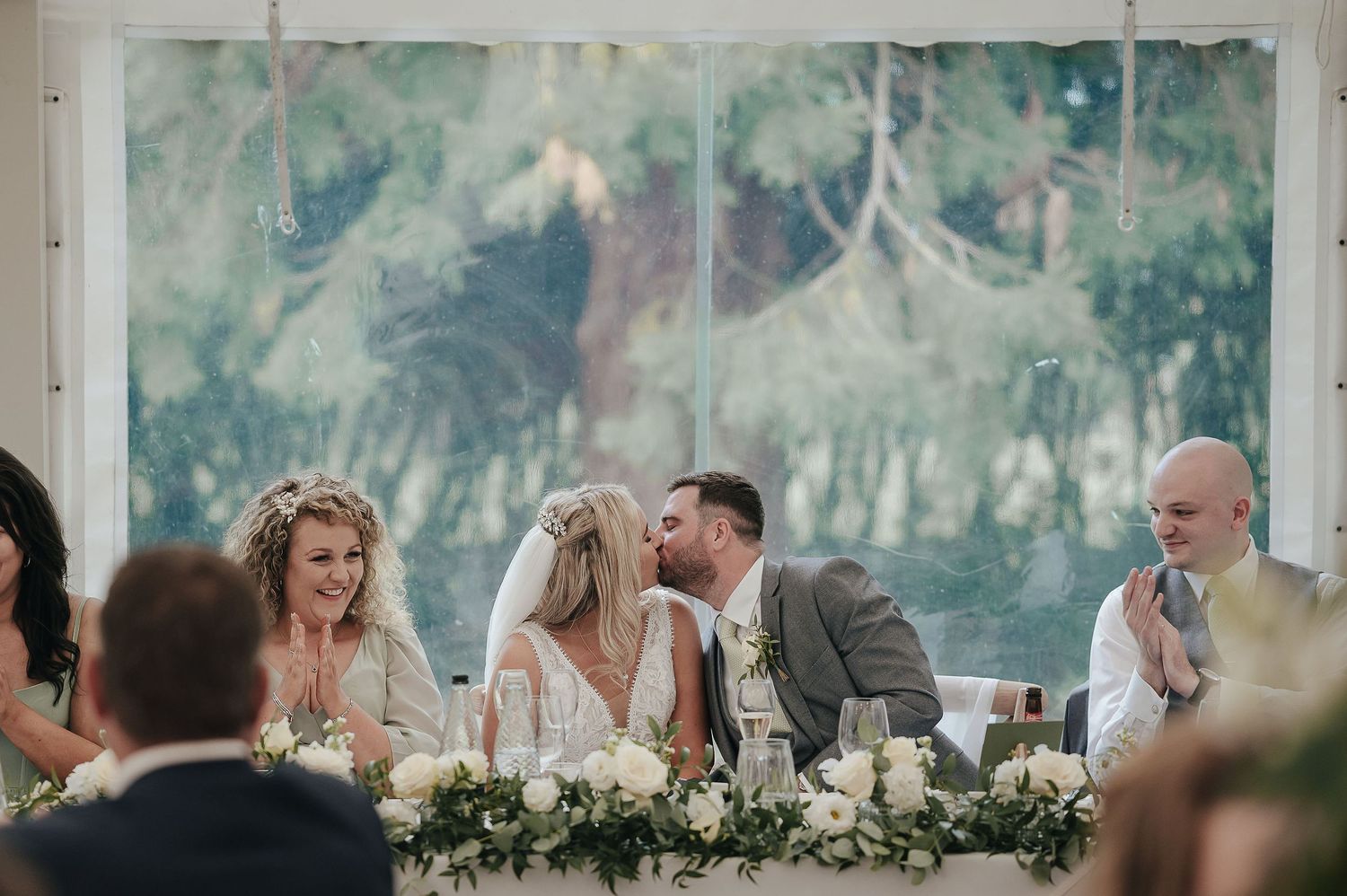 Wedding reception scene with guests seated at decorated tables during dinner celebration.