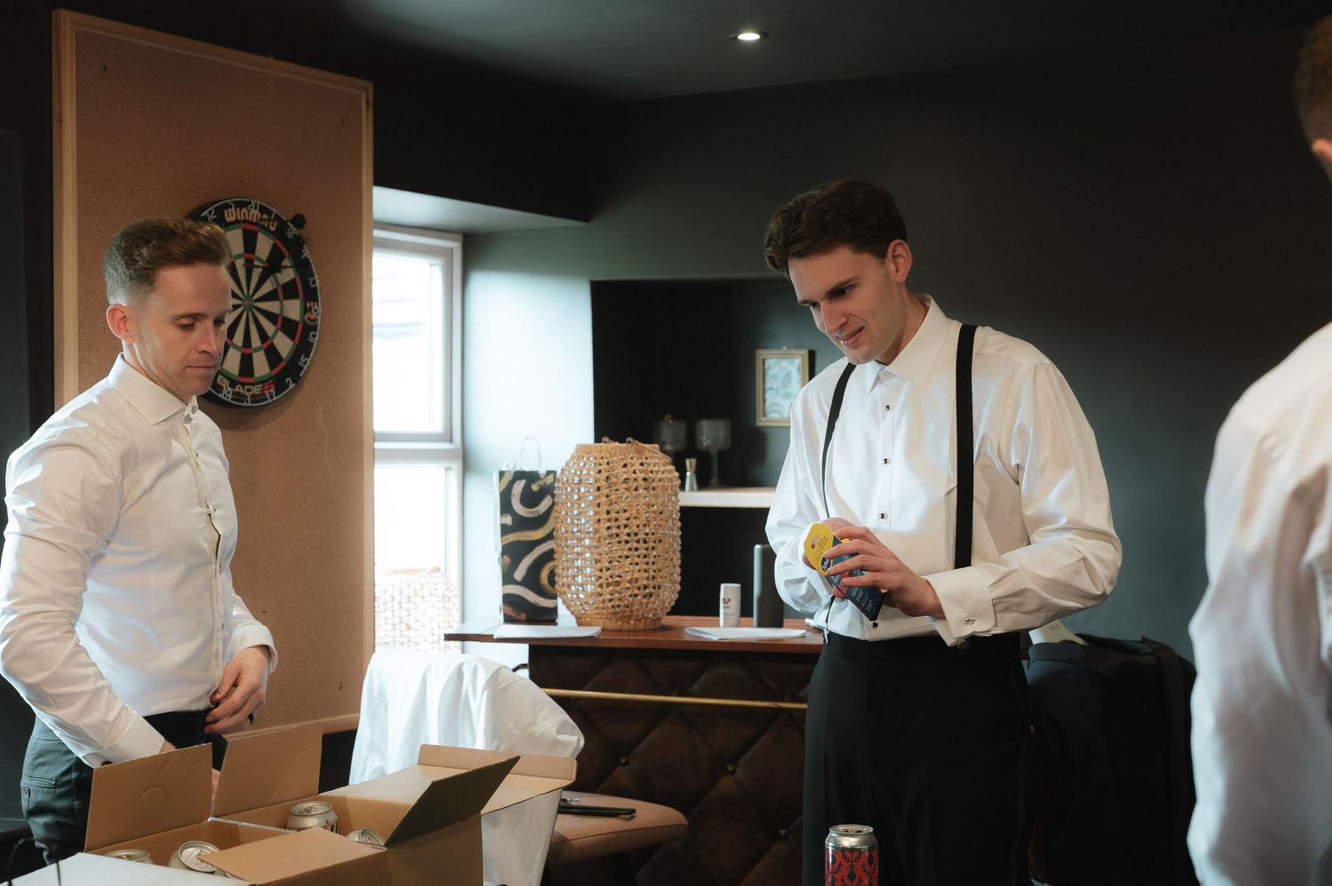 Chefs in white coats work diligently in a professional kitchen preparing food at various stations.