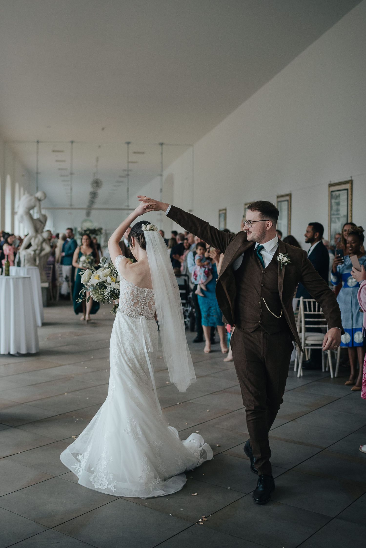 A romantic first dance moment in an elegant white reception venue.