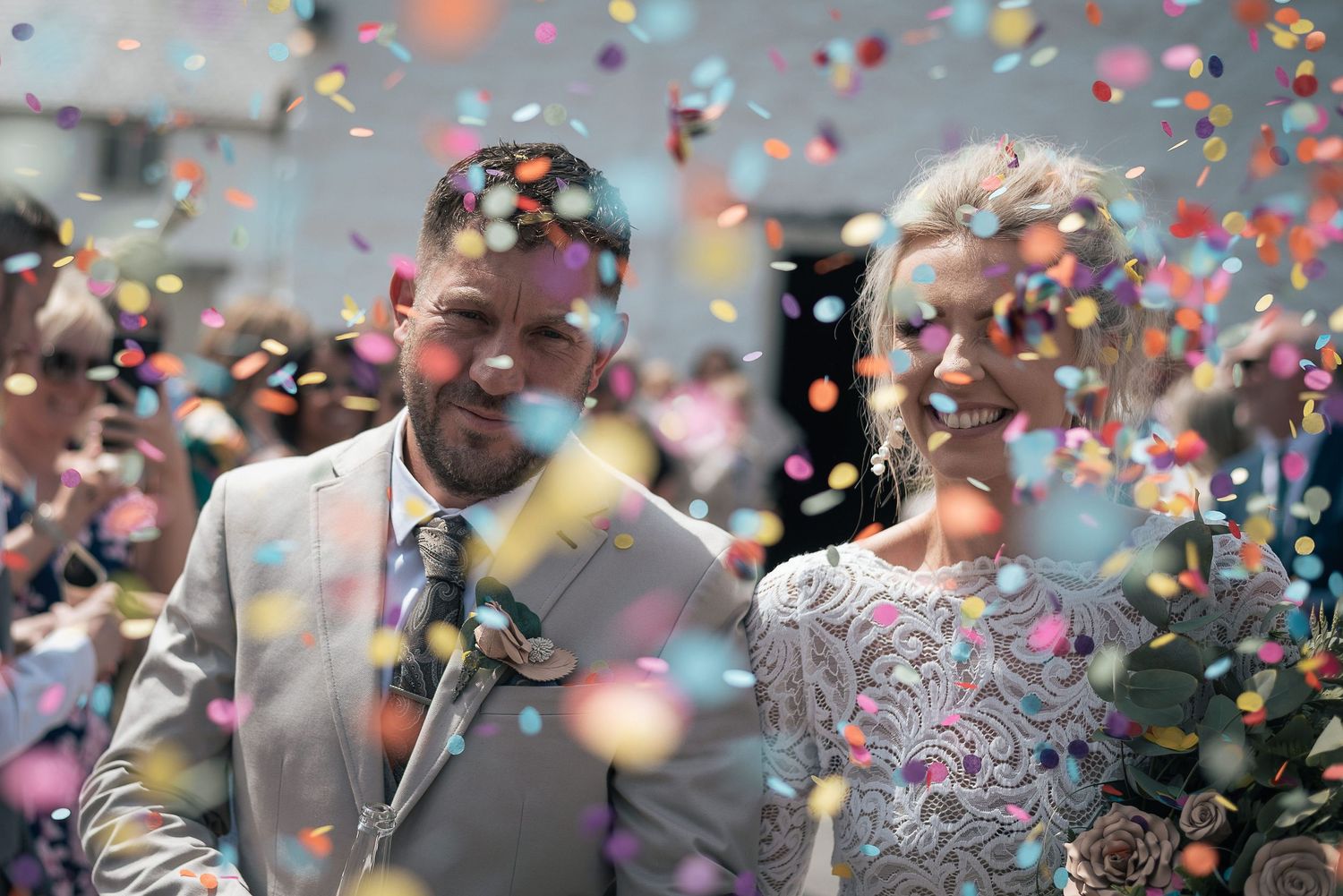 Wedding celebration with vibrant confetti falling around the happy couple.