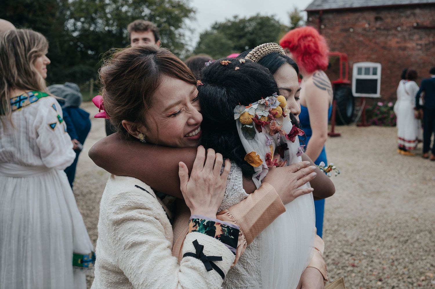 Wedding guests celebrating with emotion during outdoor reception.