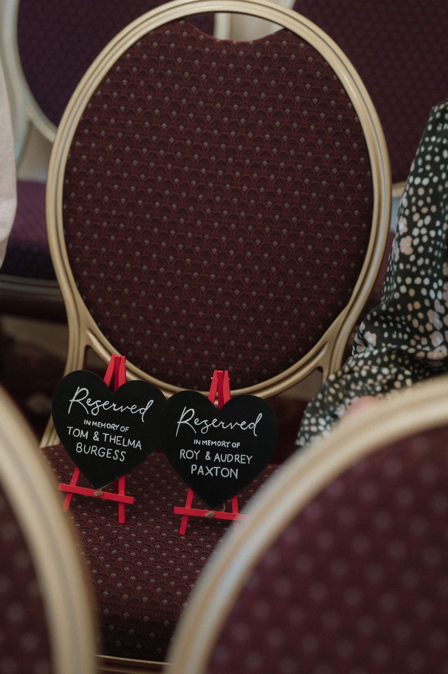 Wedding seating chart with wooden embroidery hoops displaying guest names and table assignments.