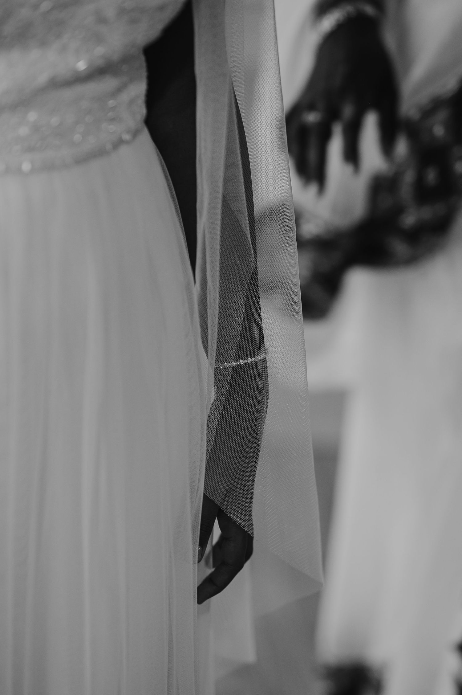 A black and white detail shot of wedding dress fabric and shadows.