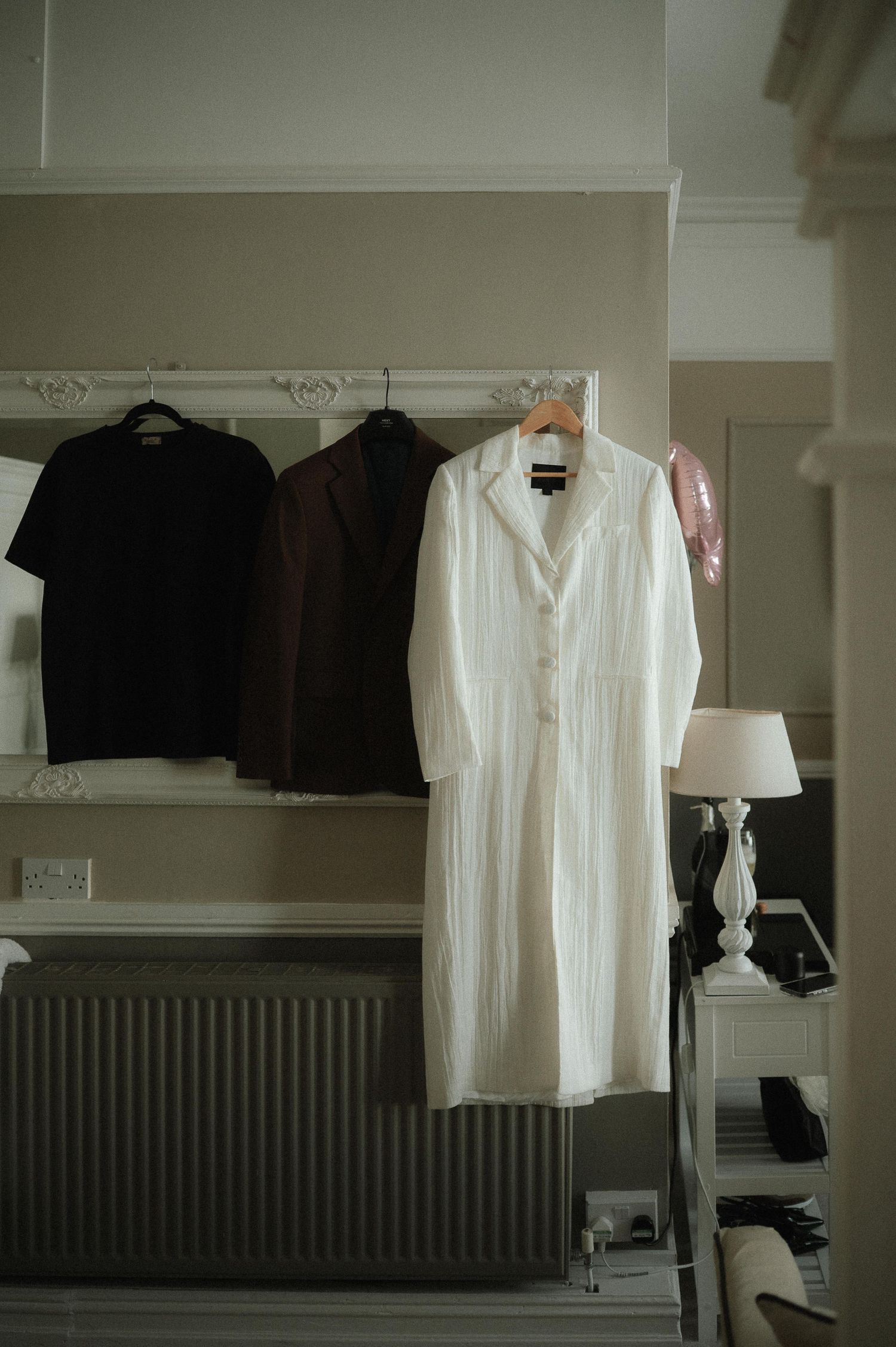 White and black clothing items hanging on display in a minimalist retail store interior.