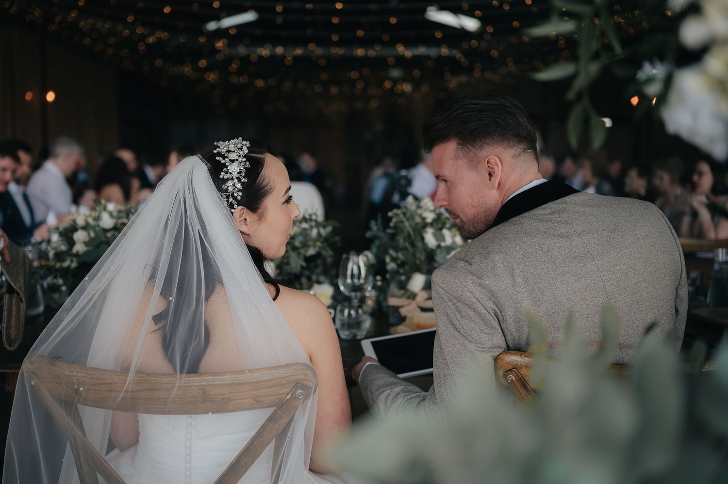 A romantic wedding reception scene with twinkle lights and floral decorations.