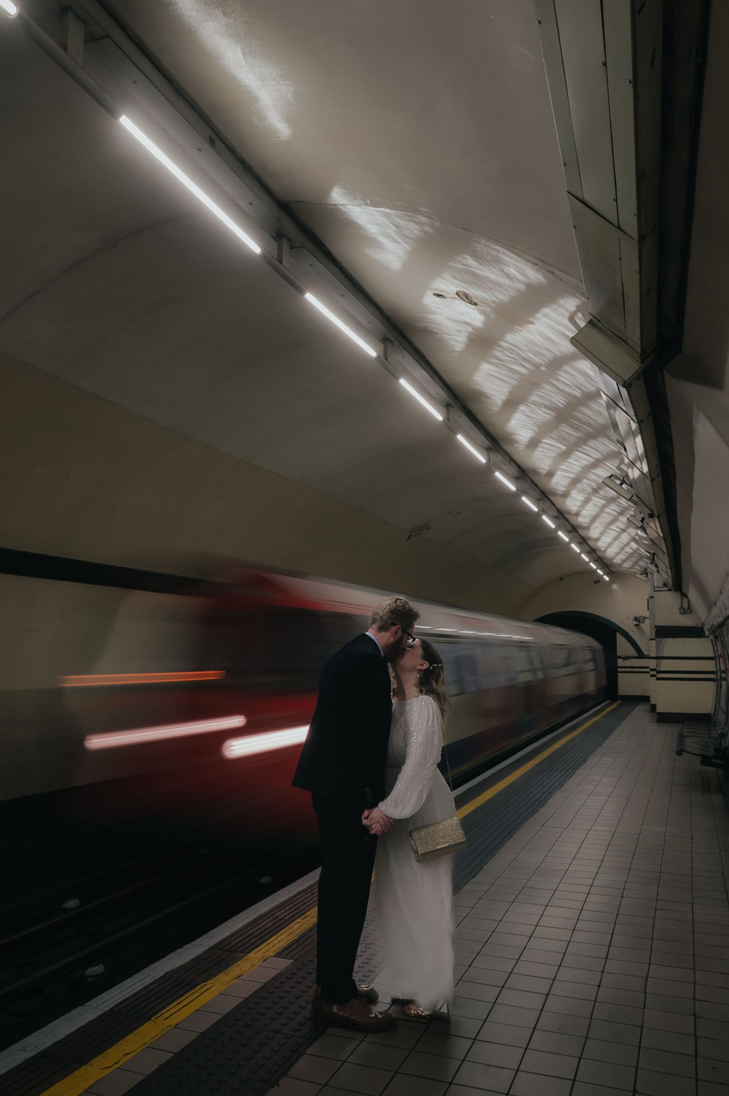 Artistic wedding photography in a subway station with motion blur and dramatic lighting. London Wedding Photographer