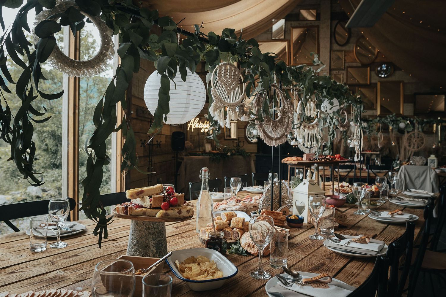 Elegant wedding table setting with hanging chandeliers and greenery decorations.