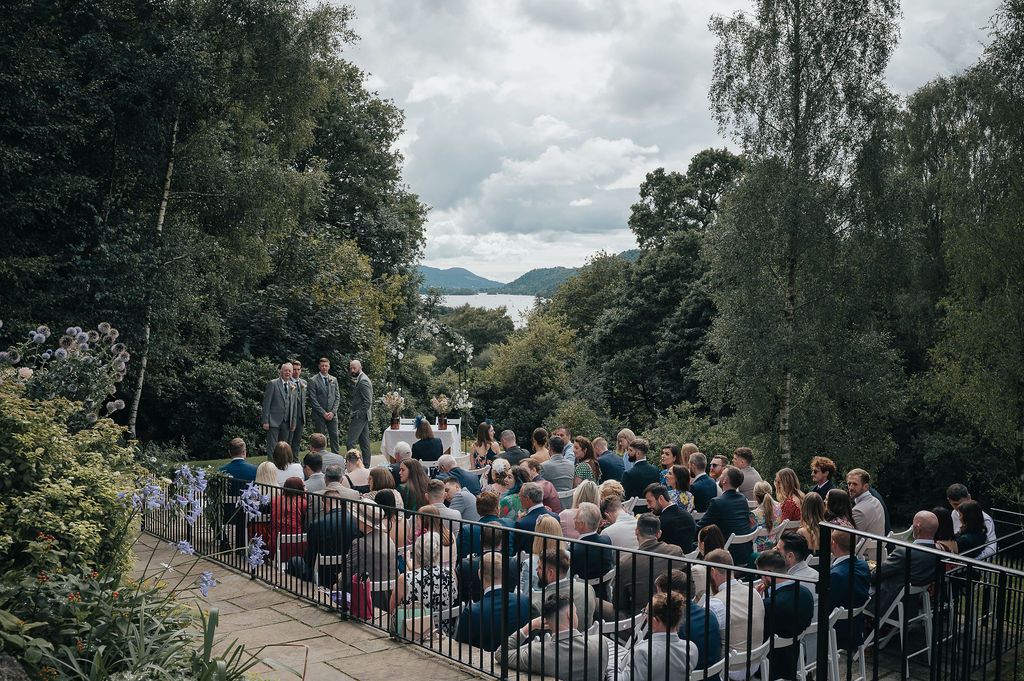 Wedding guests seated in rows overlooking a scenic mountain landscape.