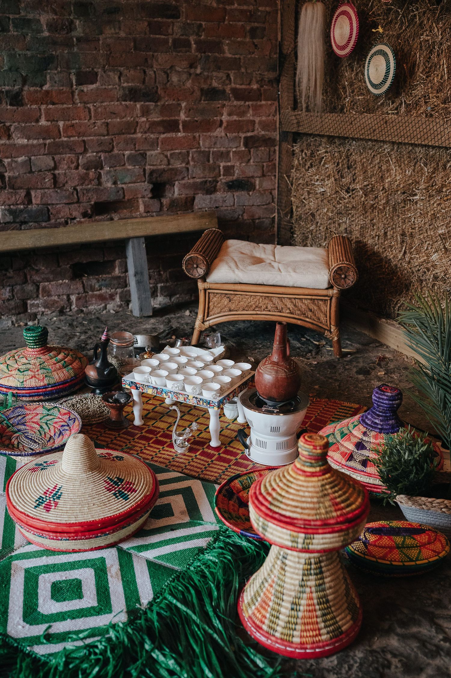 Colorful Moroccan-inspired wedding decor with woven baskets and geometric rug.