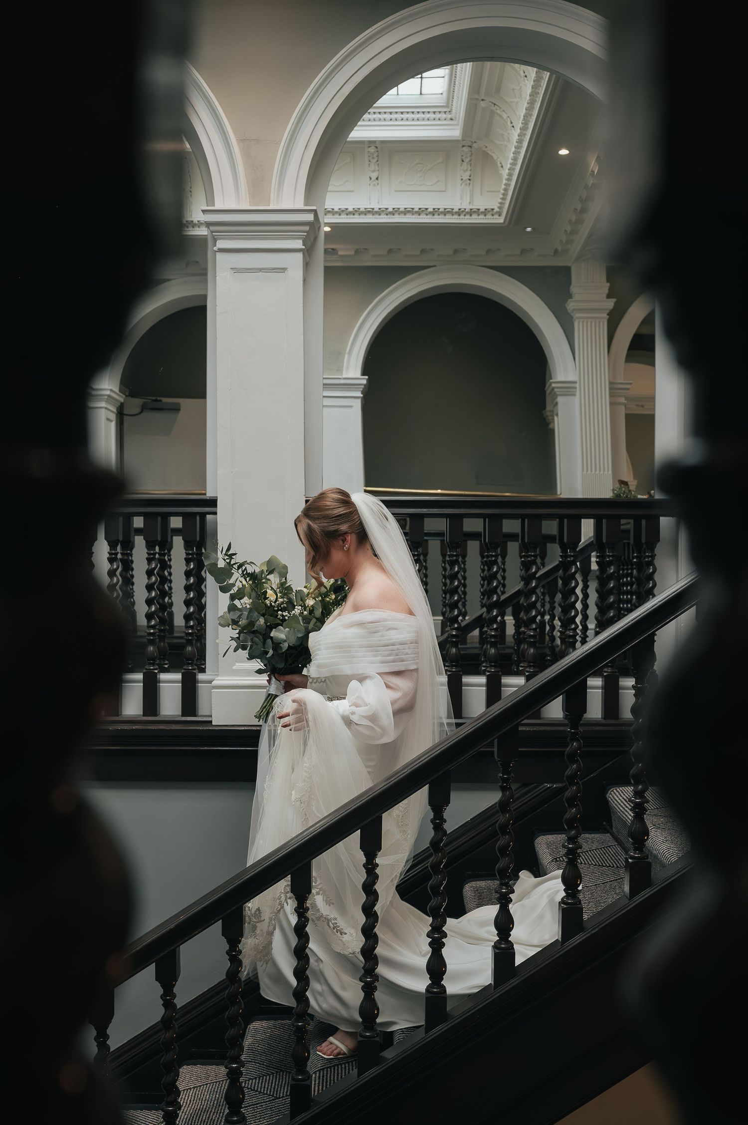 Elegant architectural wedding venue with ornate staircase and arched details.