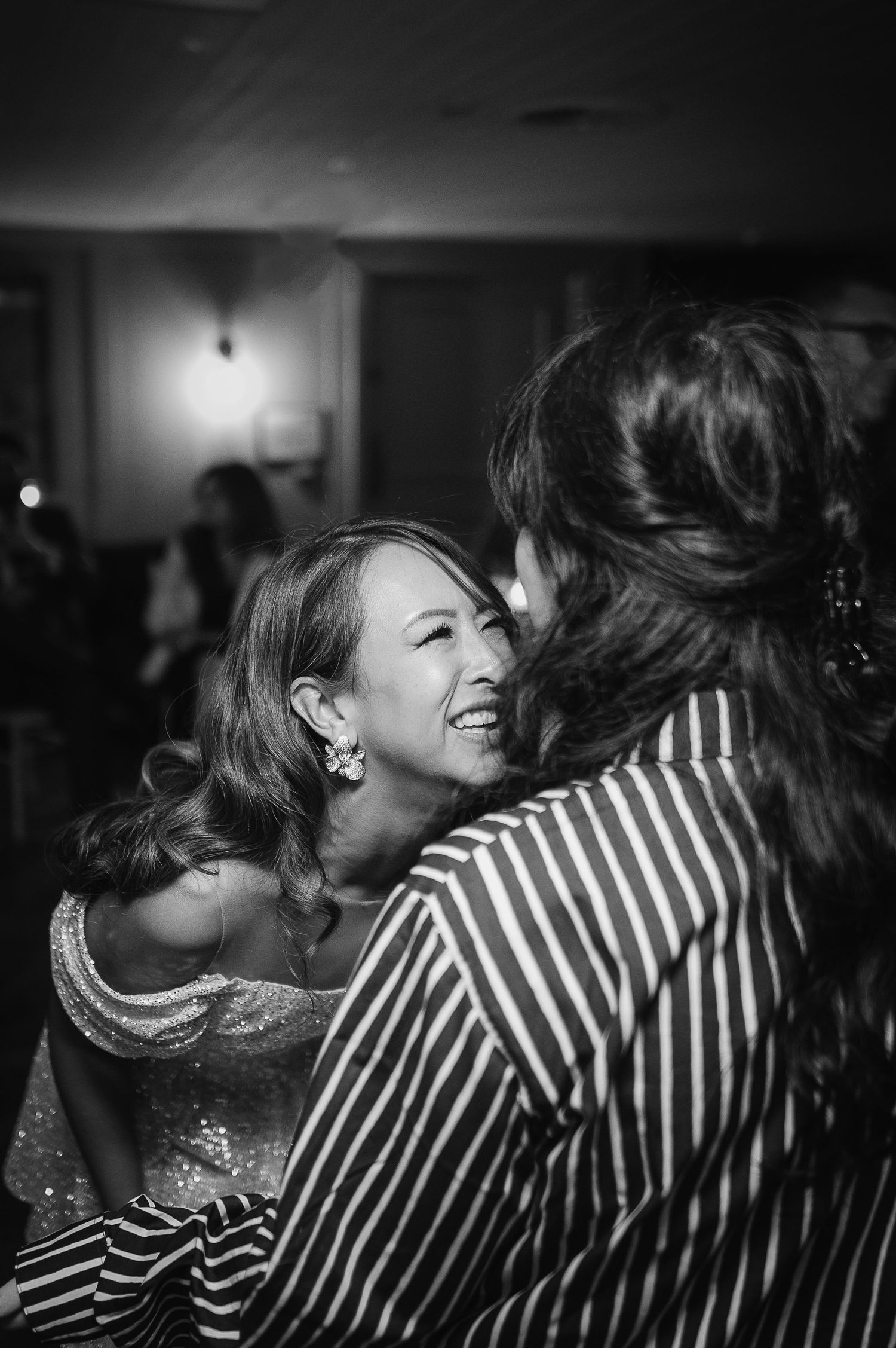 Black and white capture of joyful laughter shared during wedding festivities.