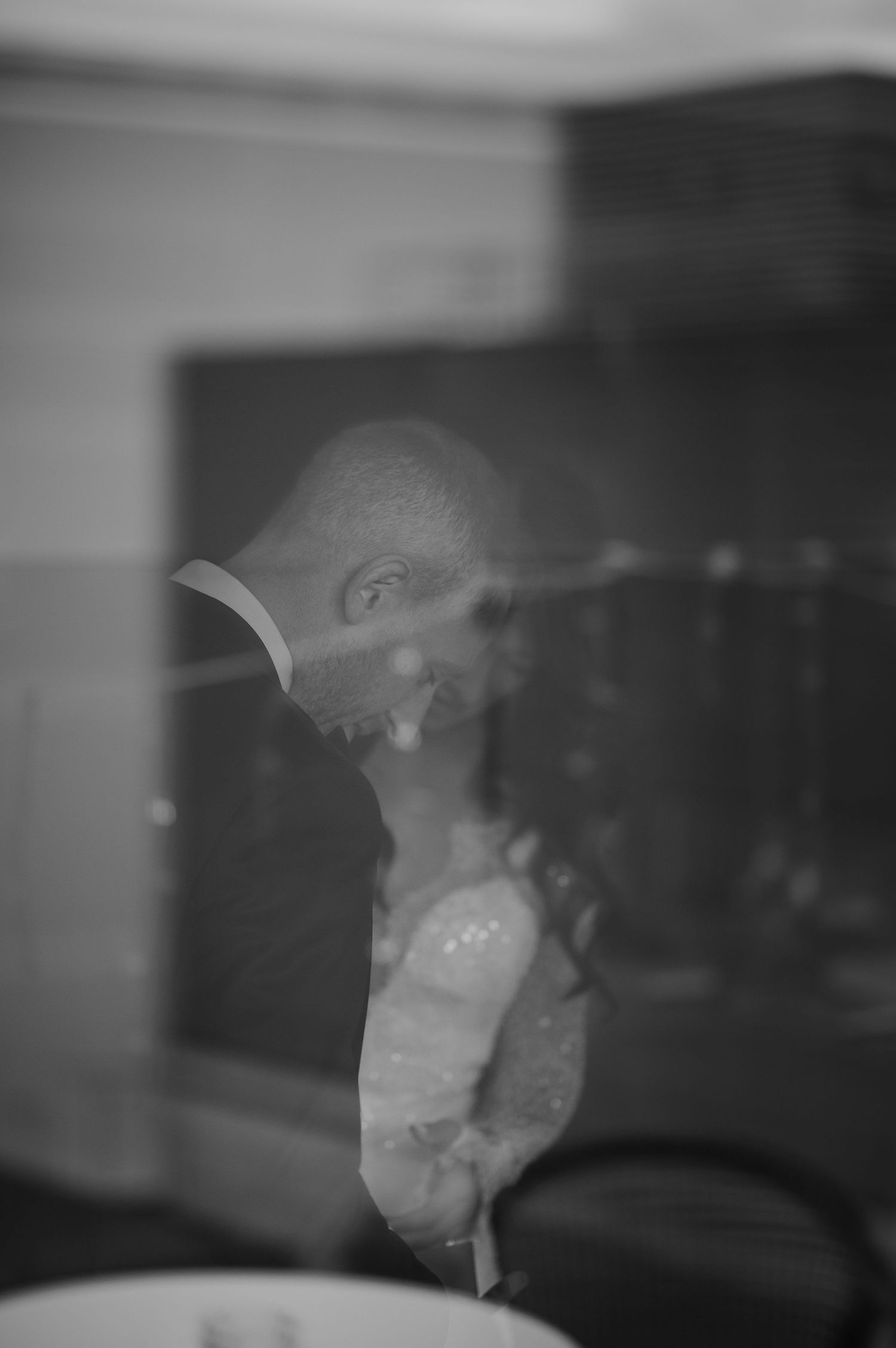 Artistic double exposure black and white photo showing silhouettes against a window.