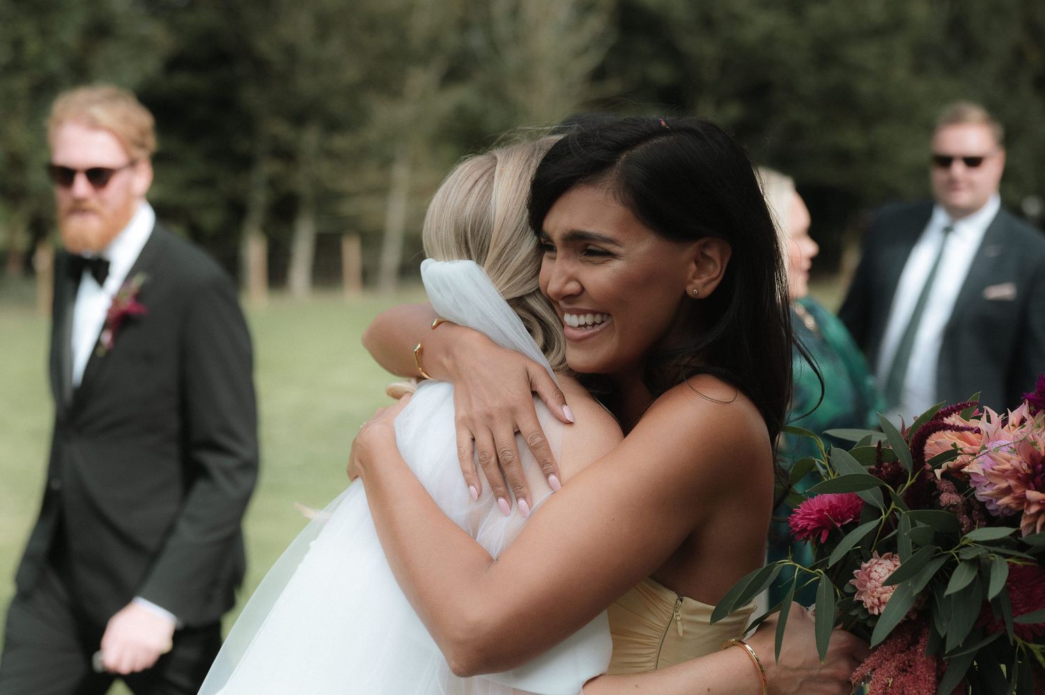 A happy moment between two people embracing and smiling during an outdoor wedding celebration.