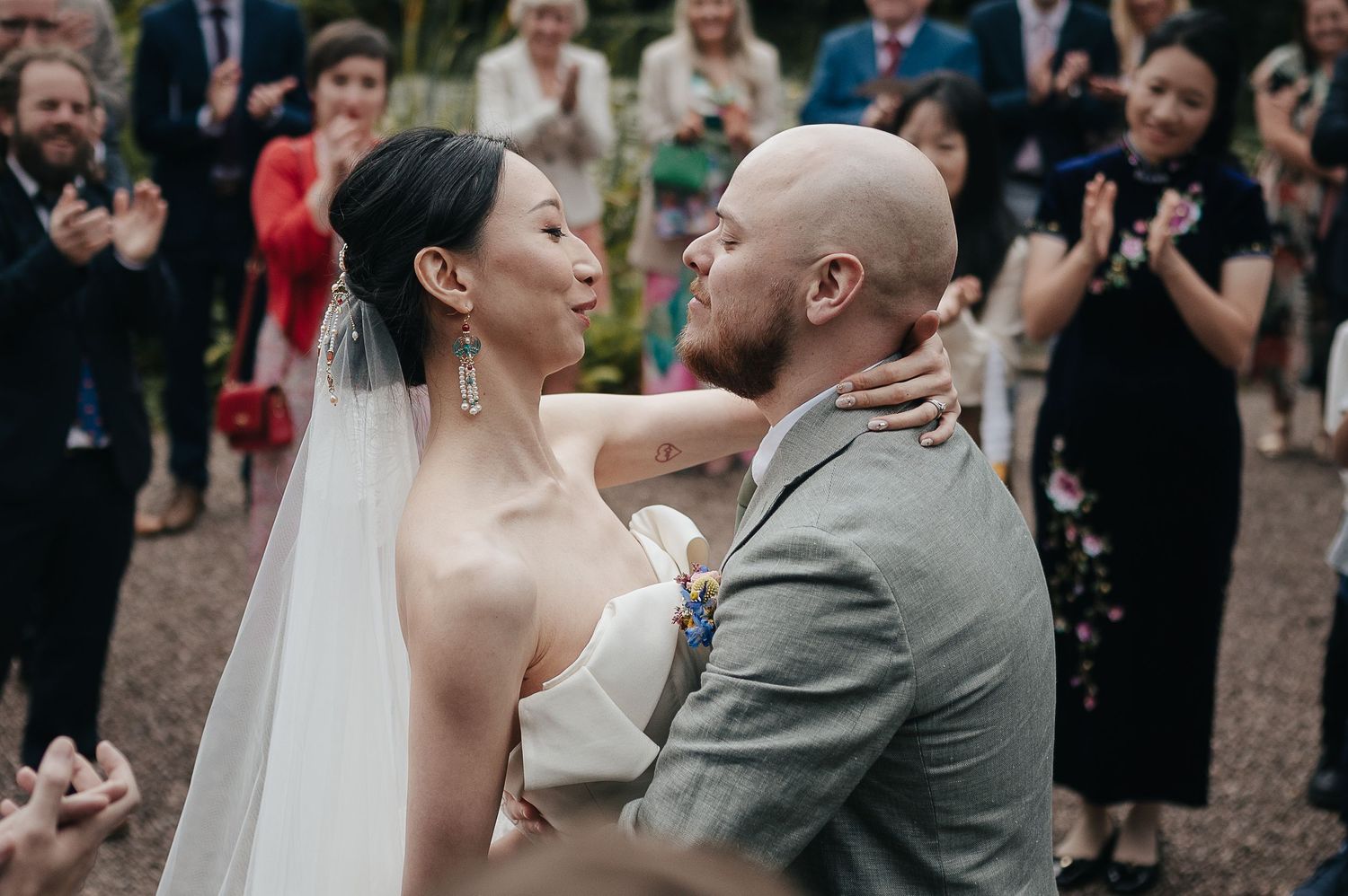 Newlyweds share an intimate moment during their outdoor garden wedding celebration.