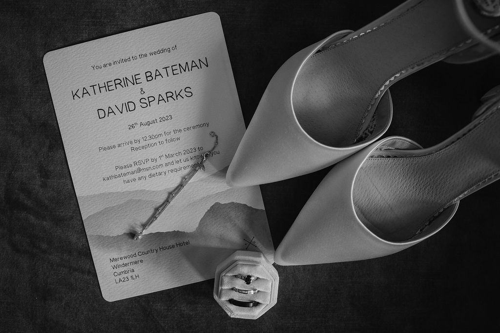 Wedding invitation and elegant silver high heels in black and white photography.