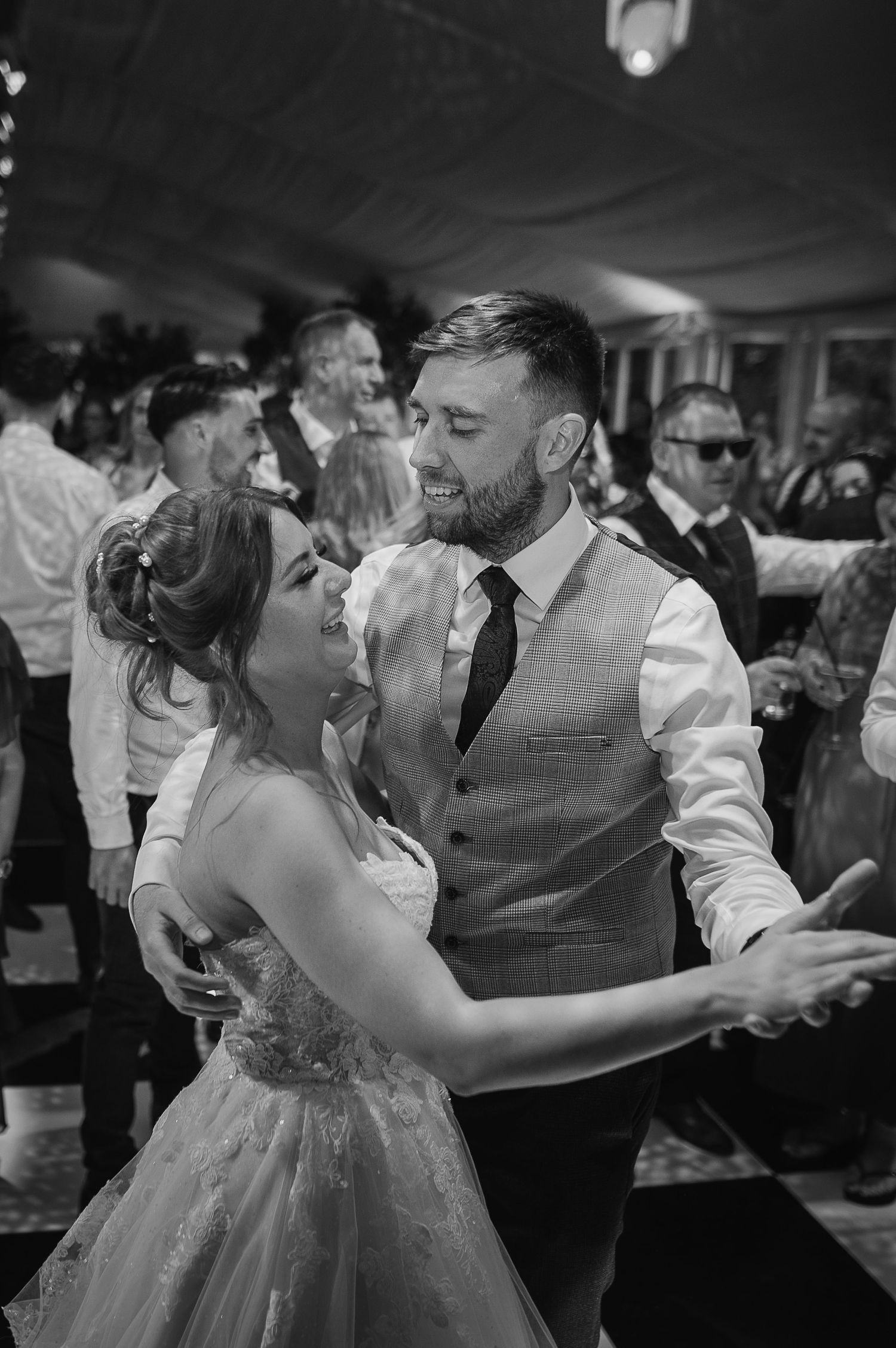 Black and white photo of a couple dancing at their wedding reception.