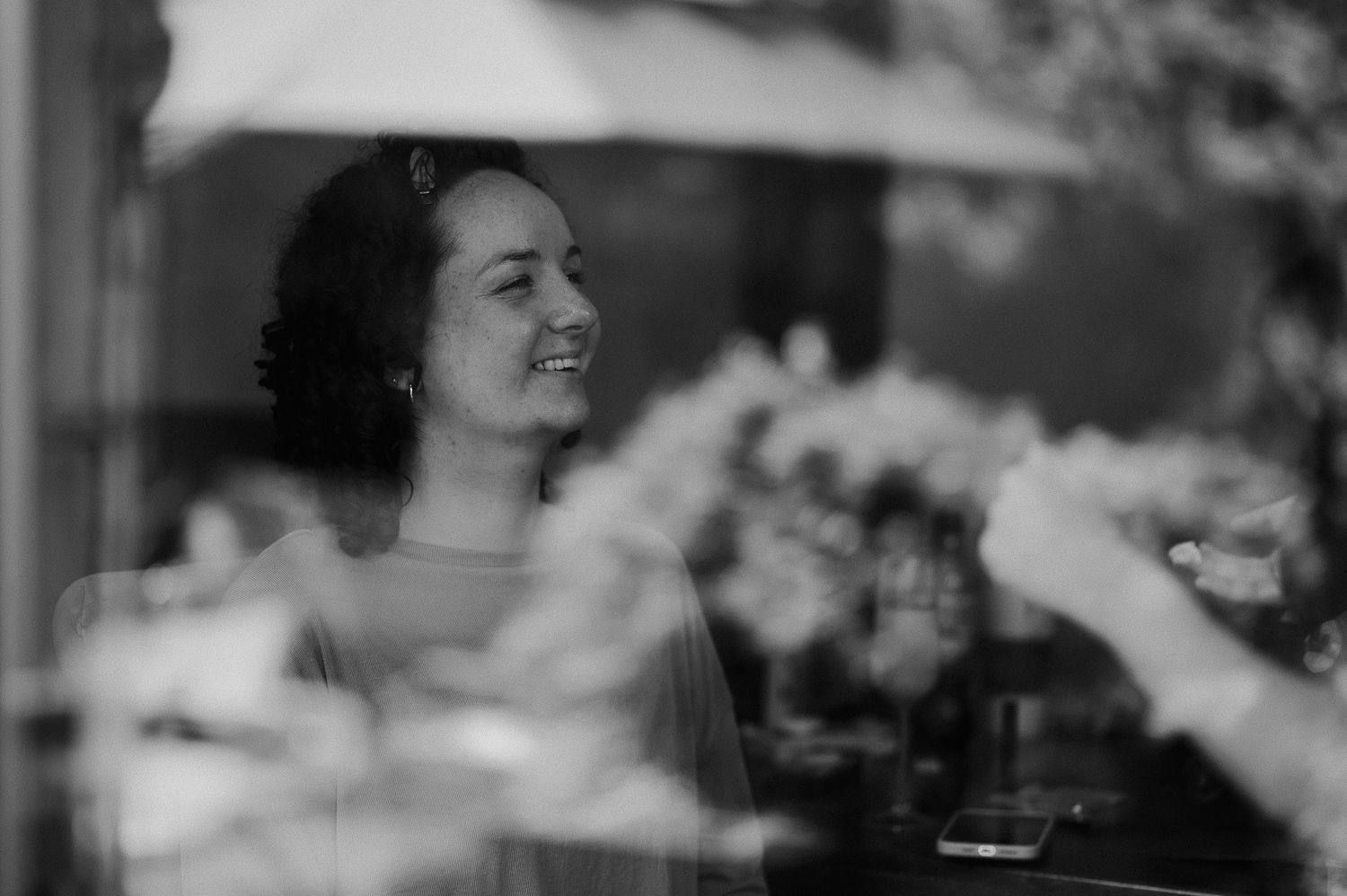 Candid black and white photo through window glass with soft bokeh effect.