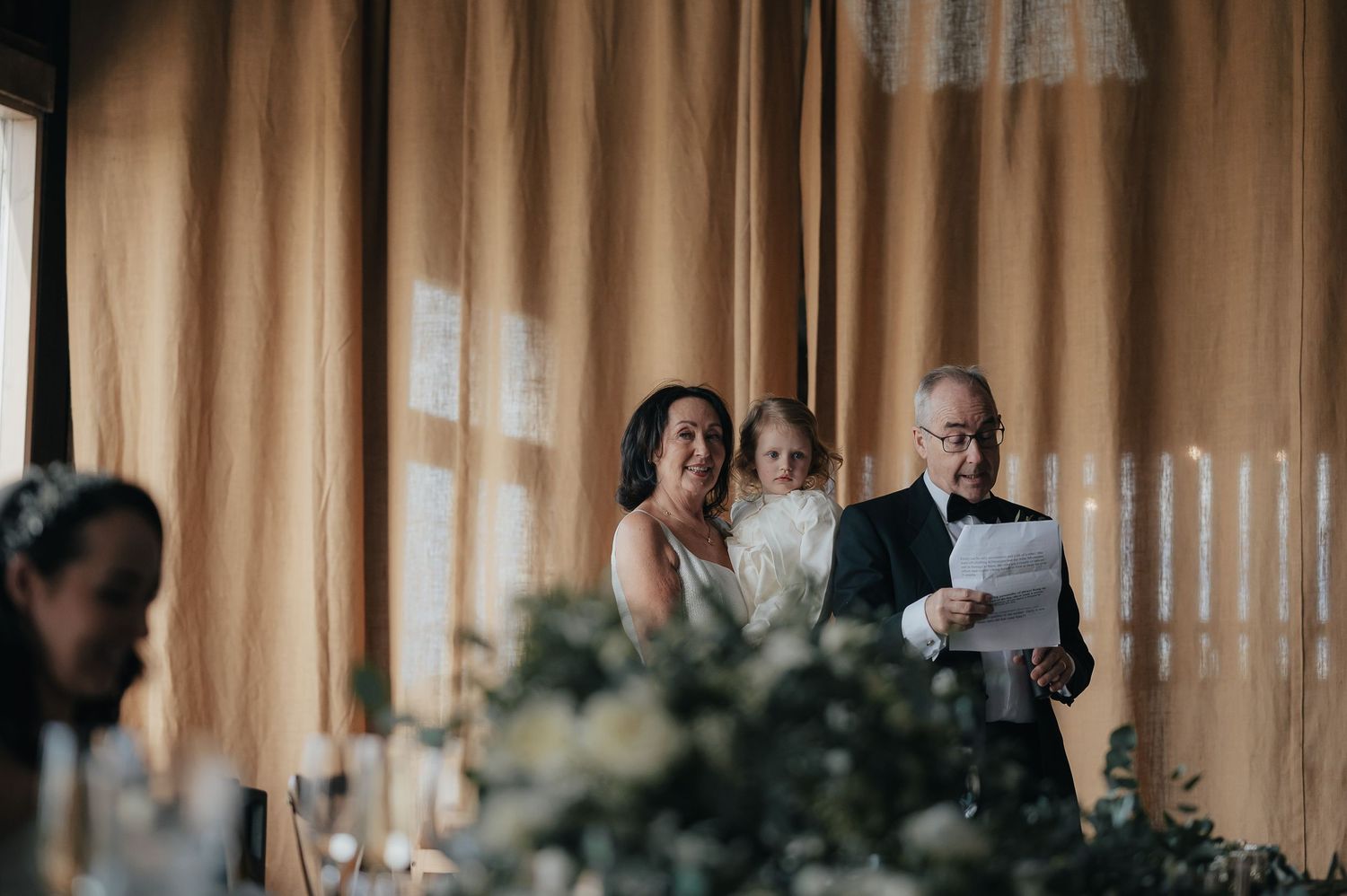 Wedding reception moment captured during emotional speeches and toasts.