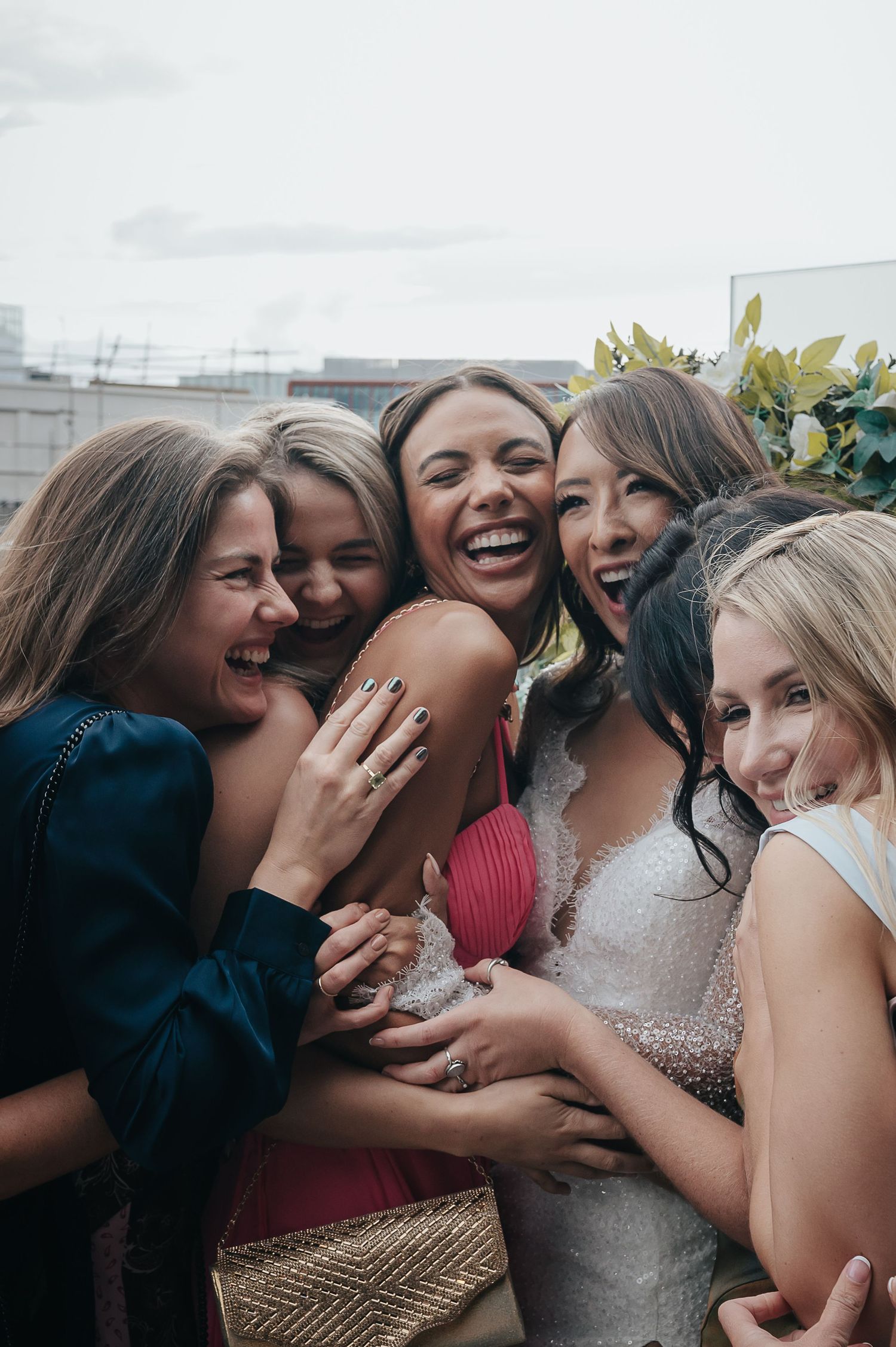Group of friends share joyful laughter during wedding celebration.
