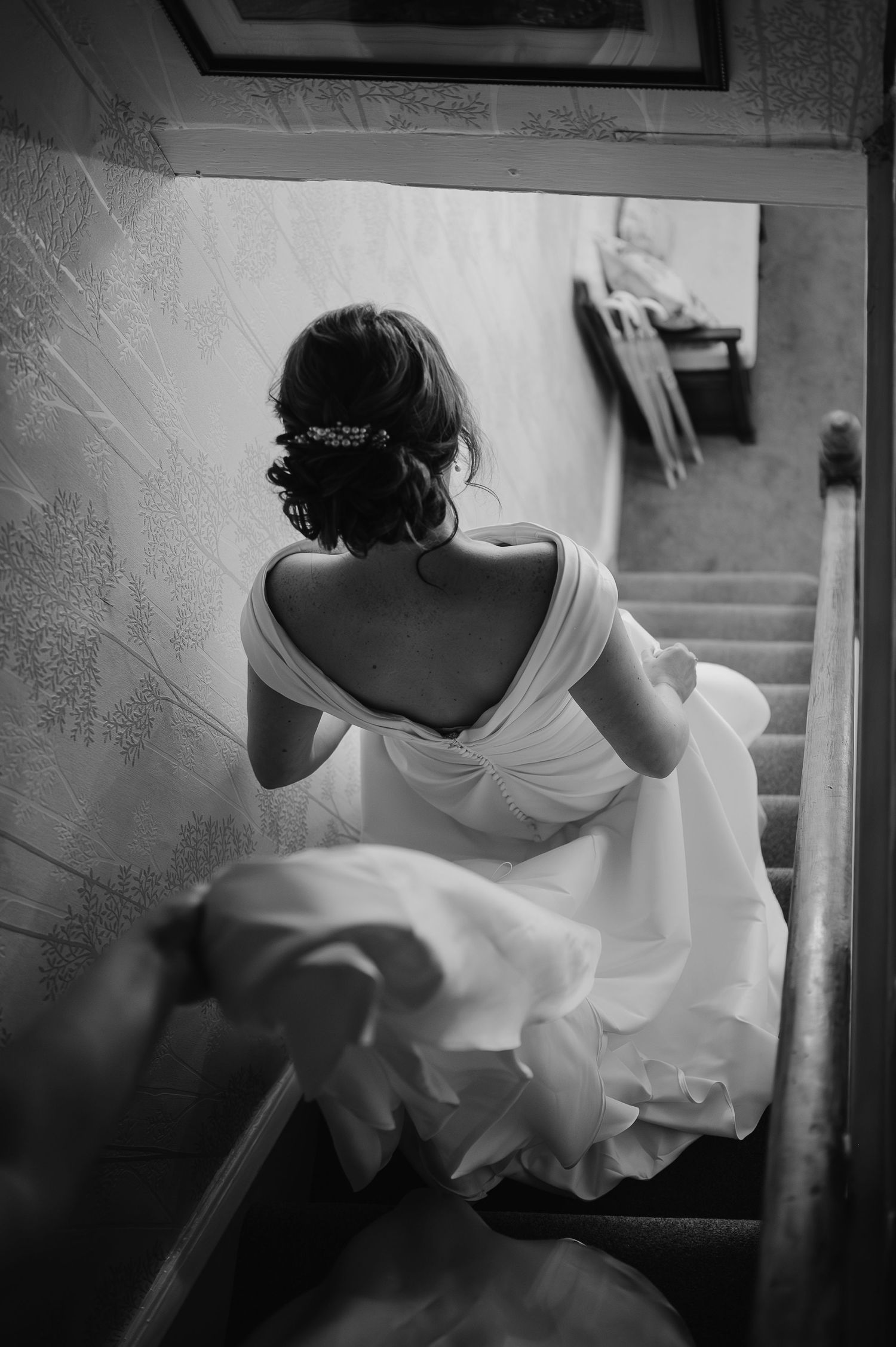 Black and white image of elegant dress detail on vintage staircase.