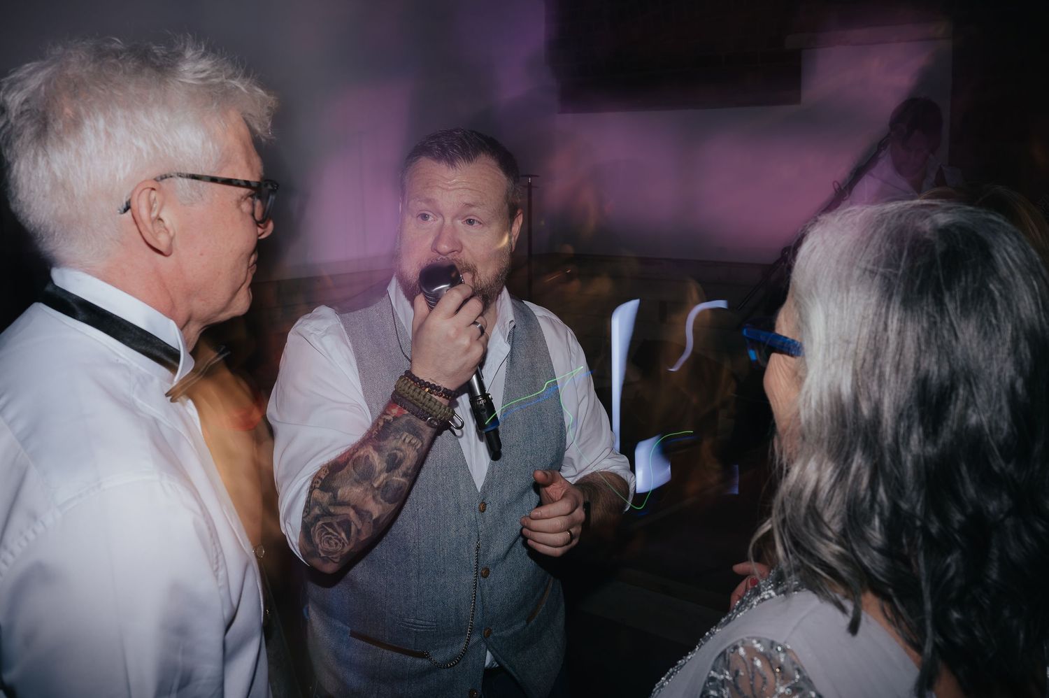 Wedding guests singing and celebrating at reception party.
