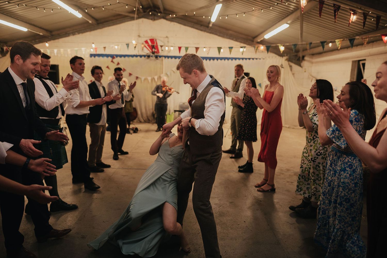Energetic dancers move across a reception hall floor during a lively celebration party.