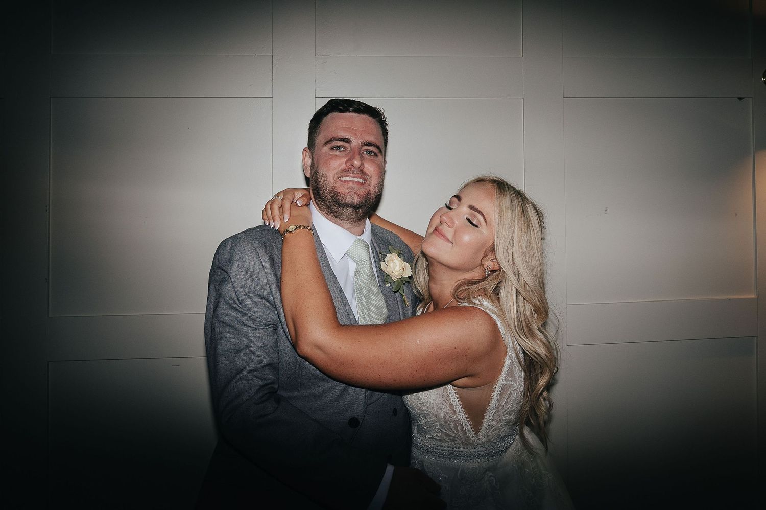 A candid moment of newlyweds sharing a joyful dance at their wedding reception.