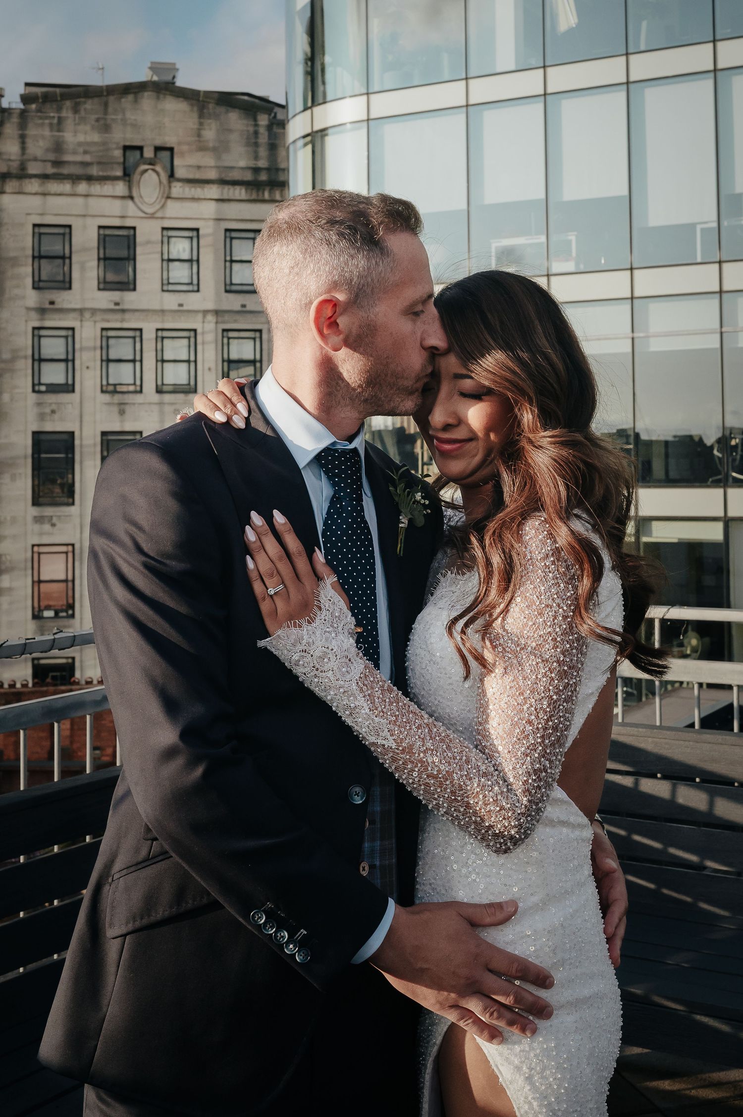 Intimate rooftop moment with city architecture in background.