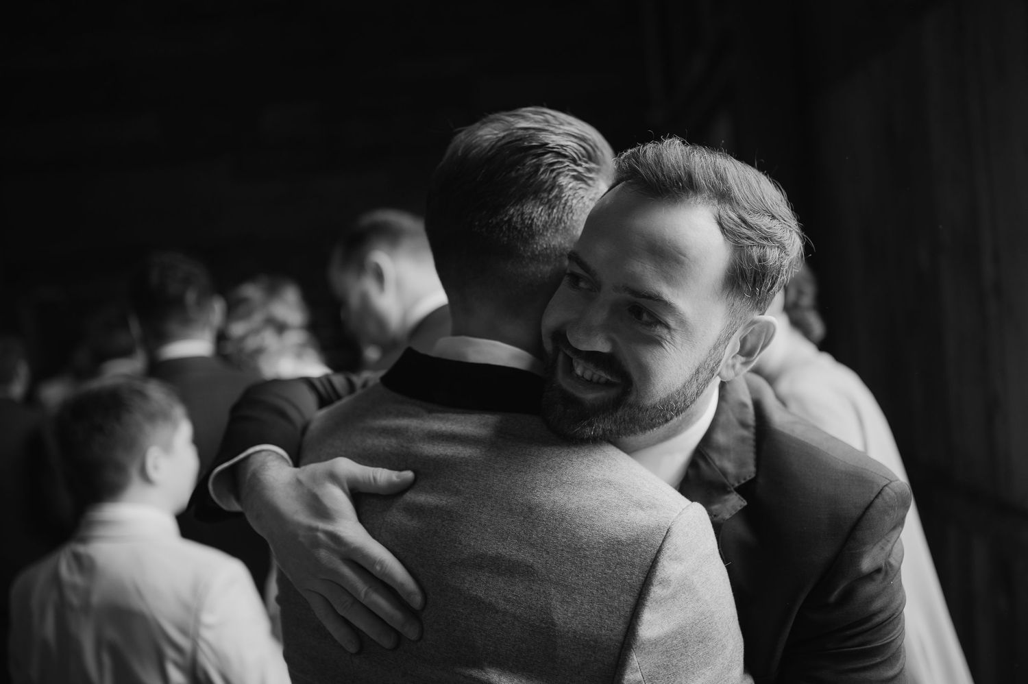 Black and white candid shot of two people sharing an emotional embrace.