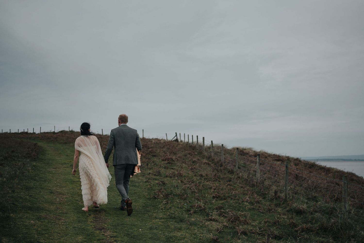 Couple walking along coastal path overlooking the ocean.