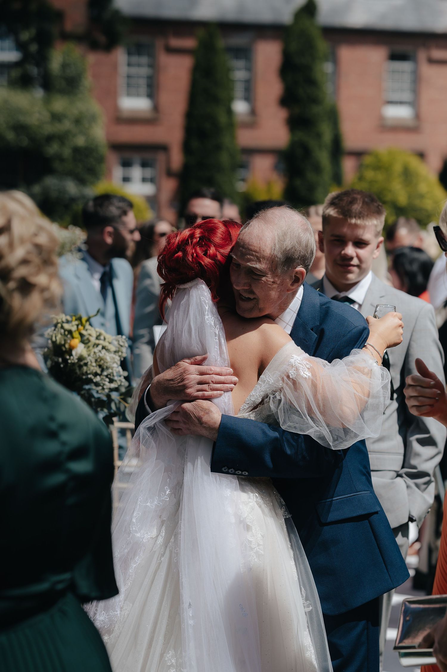 Emotional moment during wedding reception as bride hugs guest.