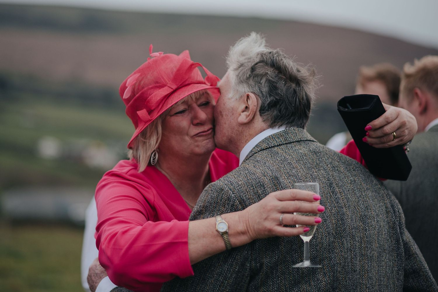 A celebratory moment at an outdoor wedding reception with guests in bright attire.