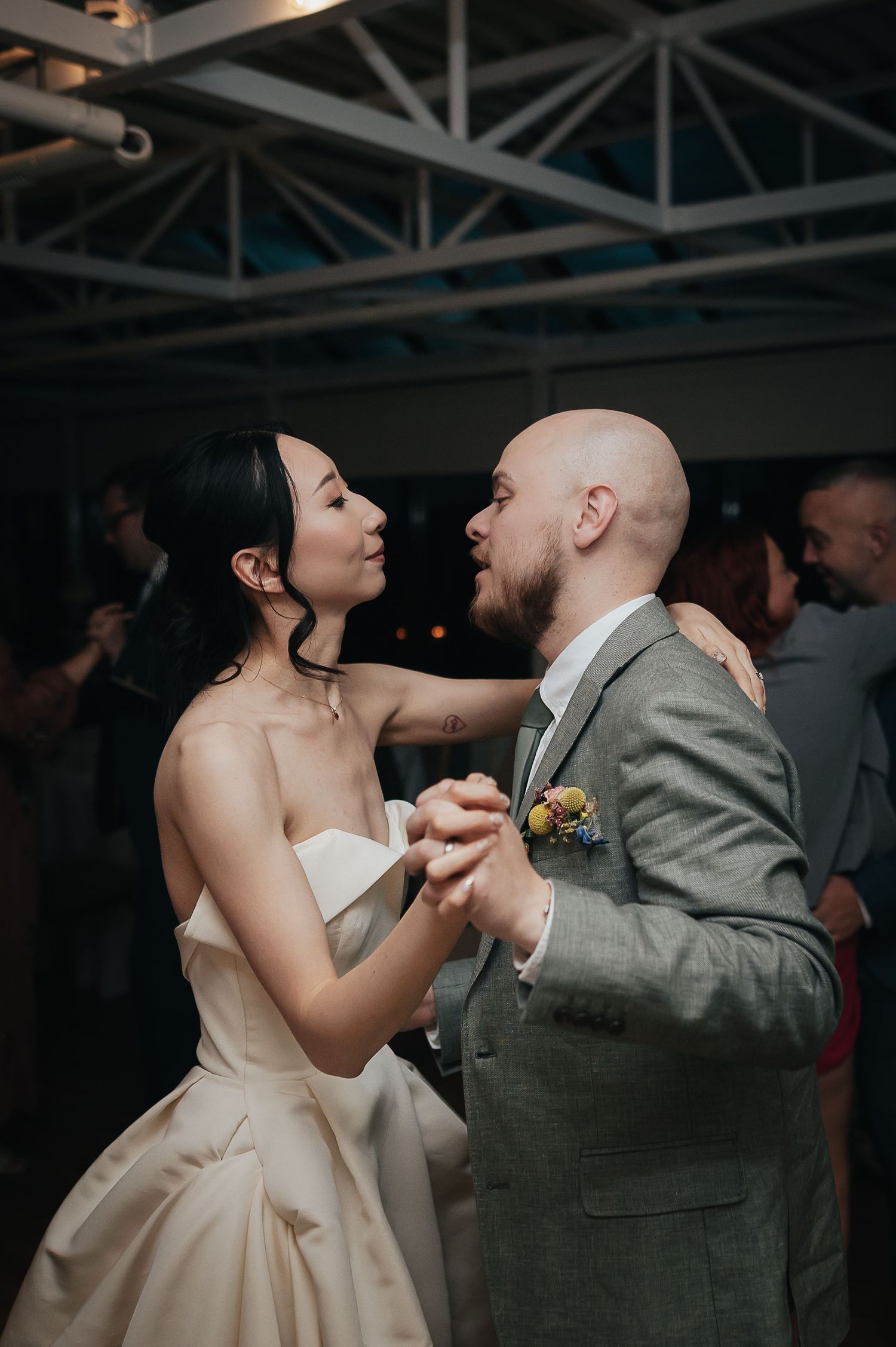 Couple shares romantic dance moment at indoor wedding reception.
