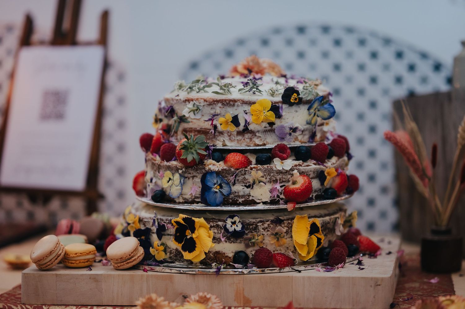 Unique multi-tiered wedding cake decorated with vibrant flowers and abstract patterns.