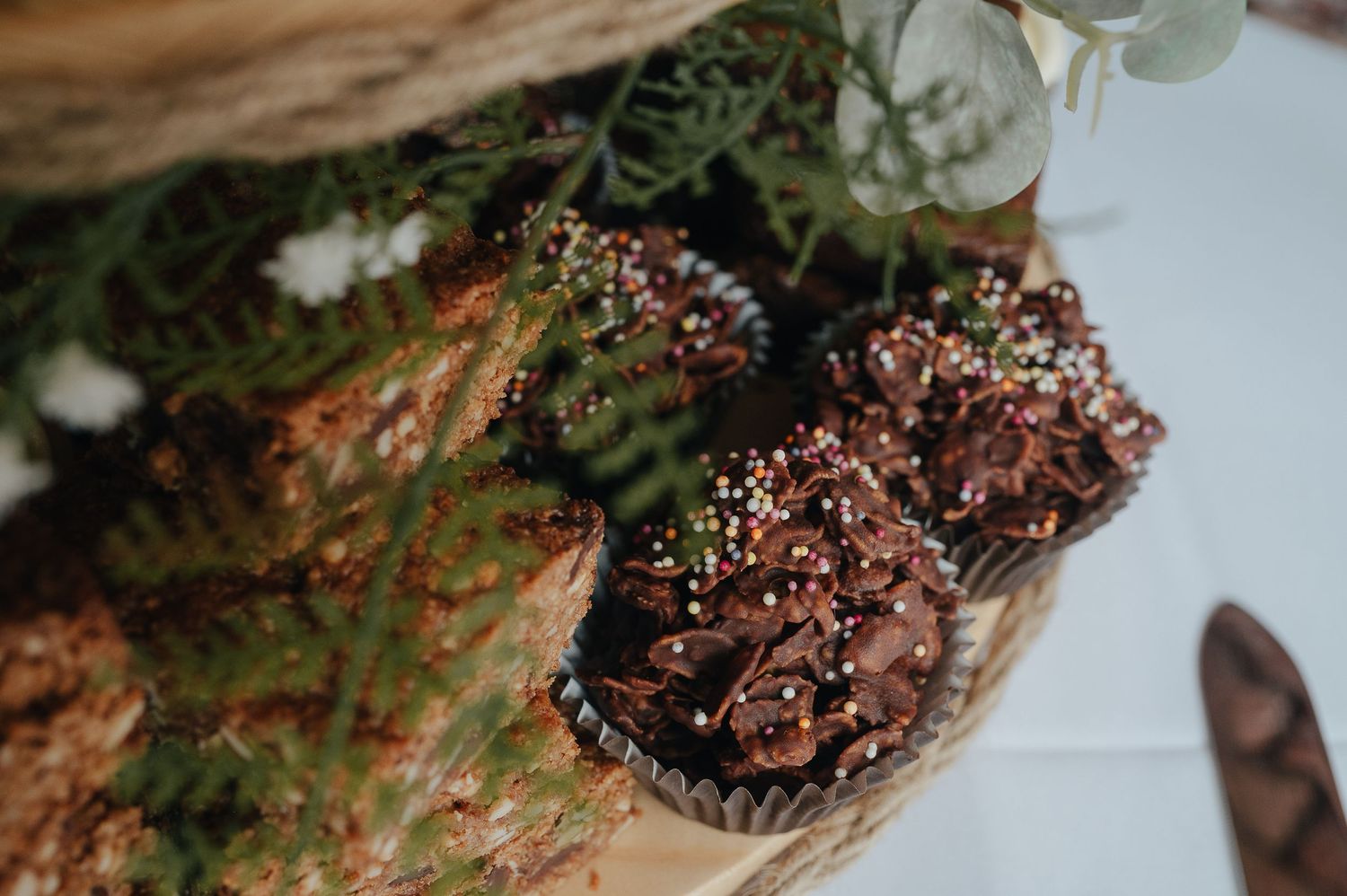 Close-up of chocolate cupcakes with sparkly decorations on a wooden surface.