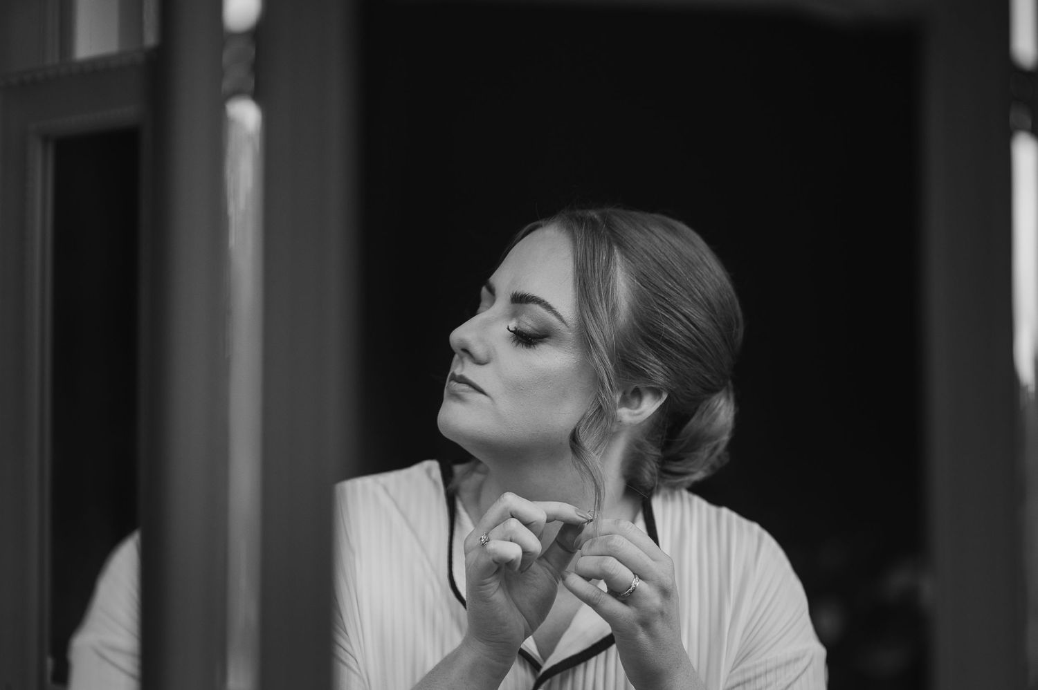 Black and white portrait showcasing elegant bridal makeup preparation.