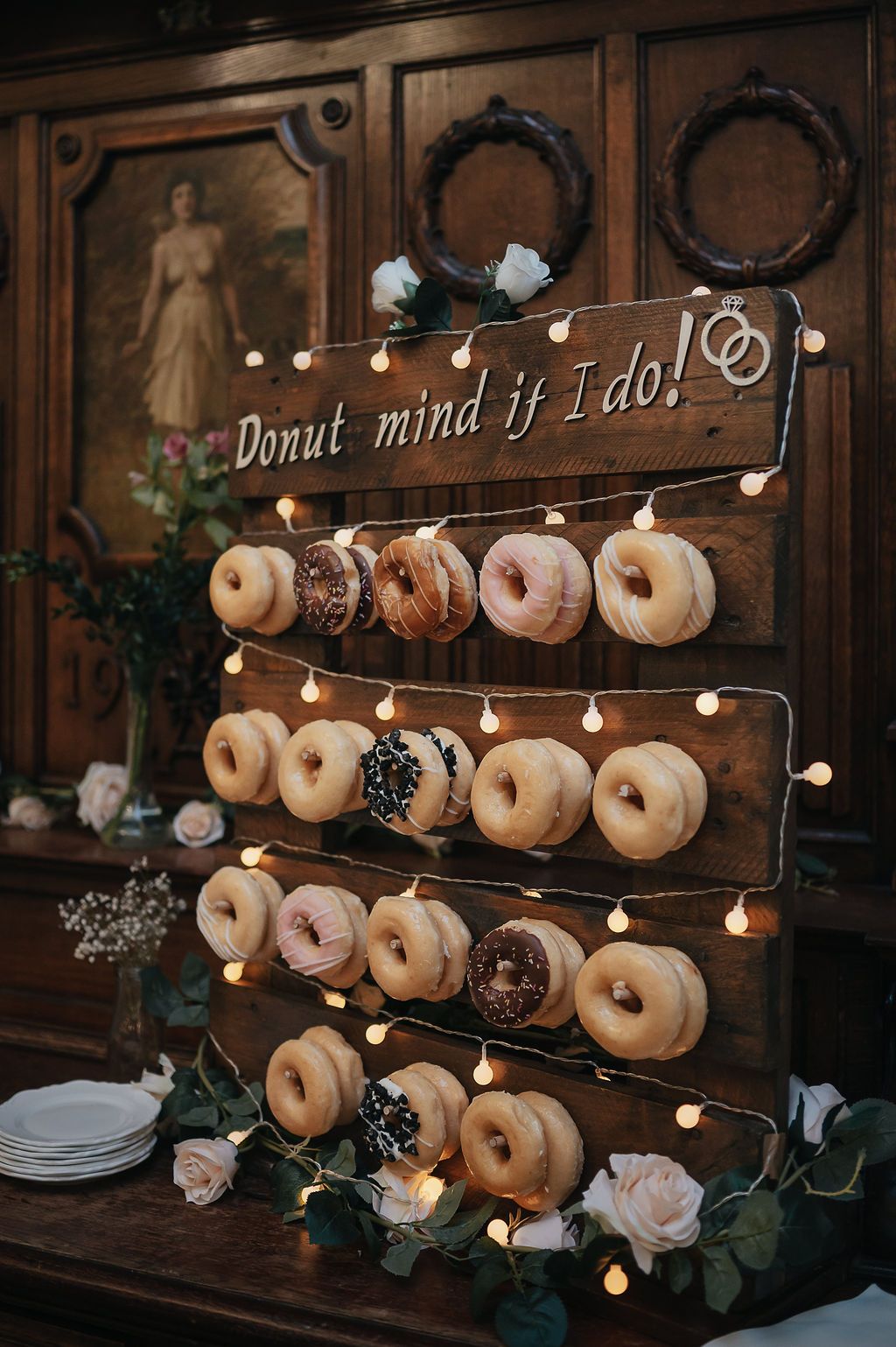 Rustic wooden donut wall display with string lights and 'Donut mind if I do!' text for wedding reception decor.
