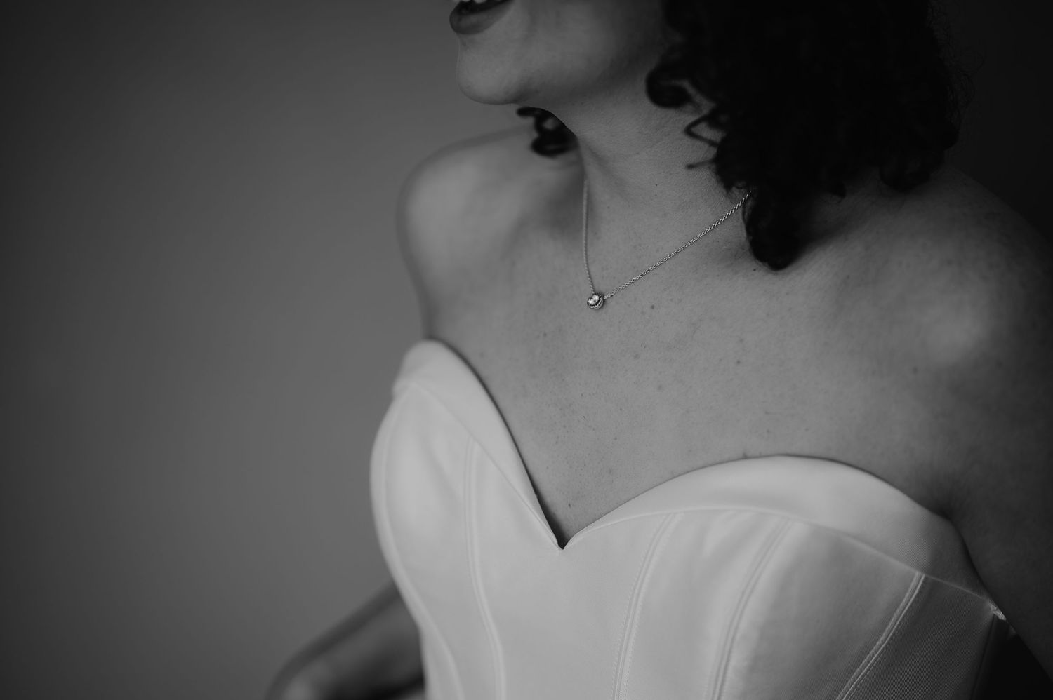 Close-up black and white photo of a strapless white dress bodice.