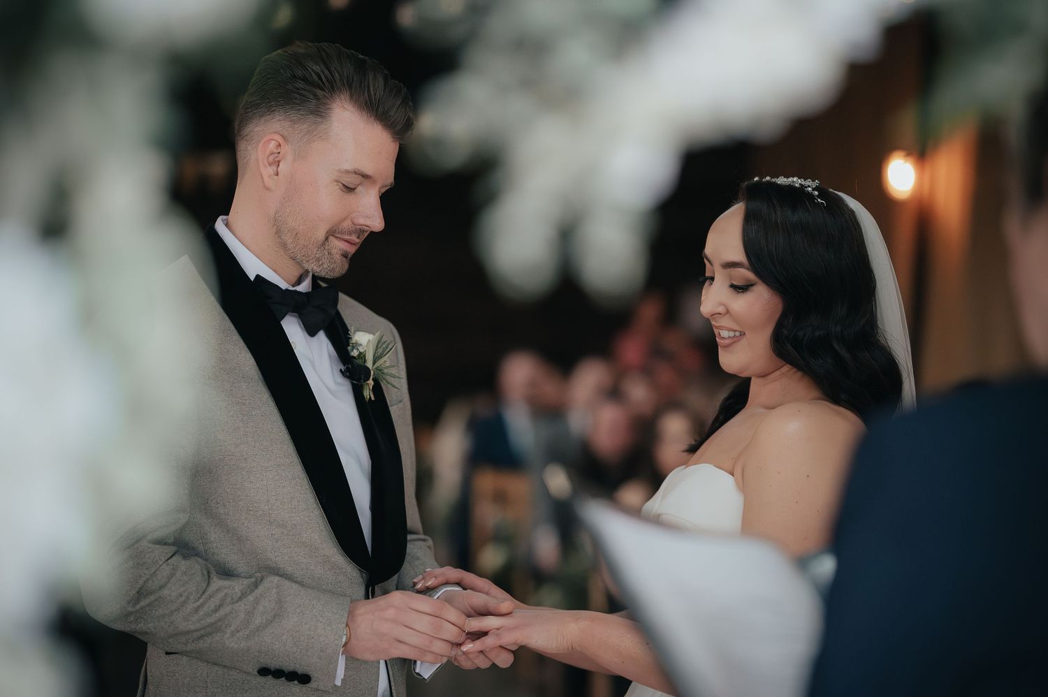 Couple shares a tender moment during their ring exchange at a romantic wedding ceremony.