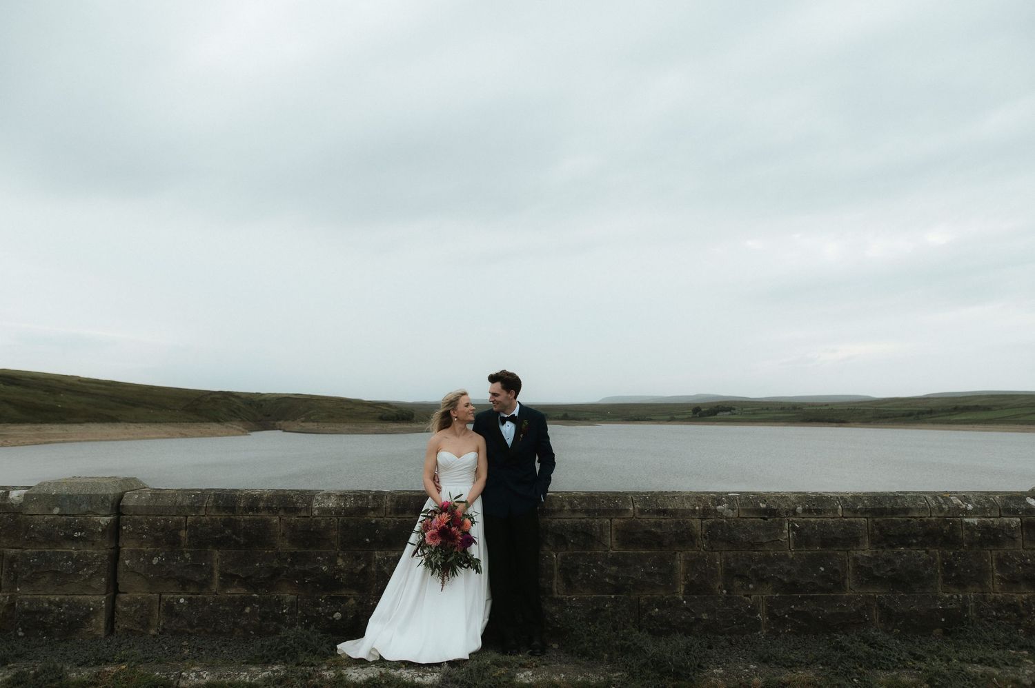 Dramatic coastal wedding photos with a stone wall and ocean backdrop. Blackton Grange Wedding. Luke Hassall Photography.