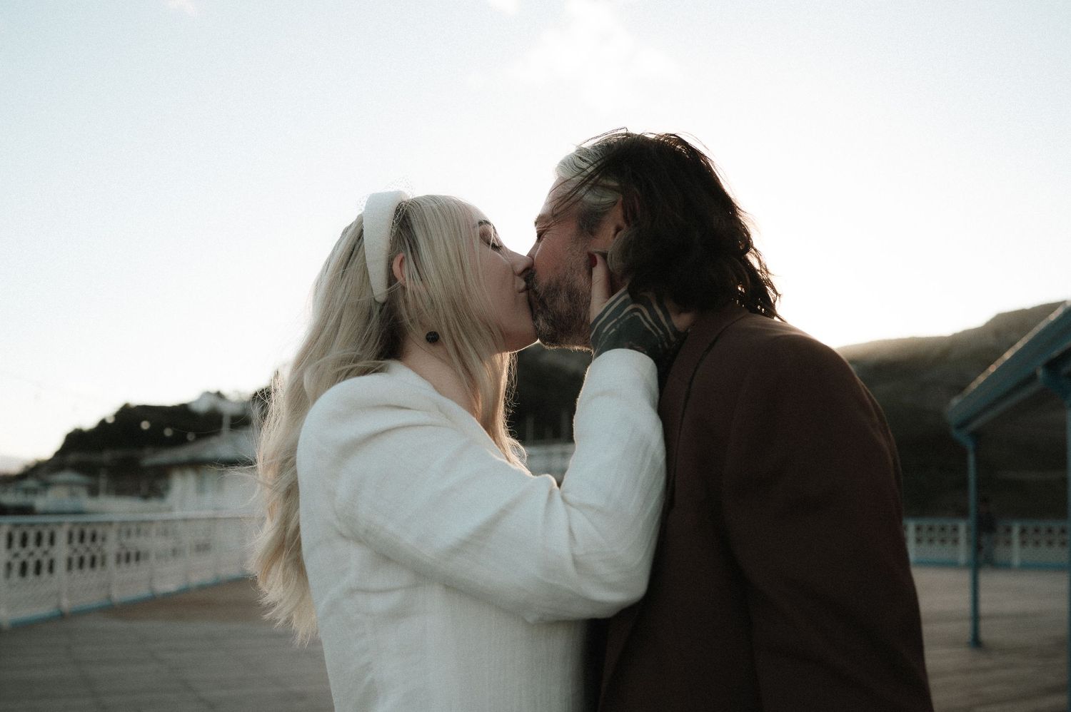 A couple embraces in silhouette against a bright background during an intimate romantic moment.