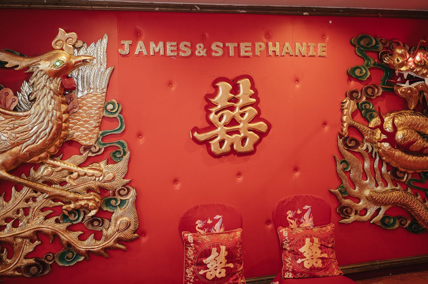 Red traditional Chinese wedding decor with dragon motifs and the names James & Stephanie displayed.