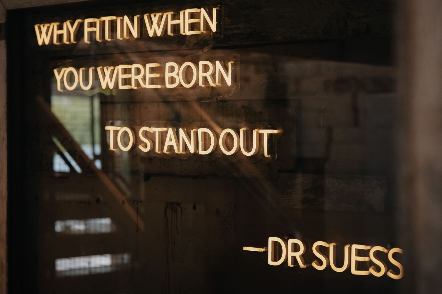 Neon sign displaying an inspirational Dr. Seuss quote about standing out.