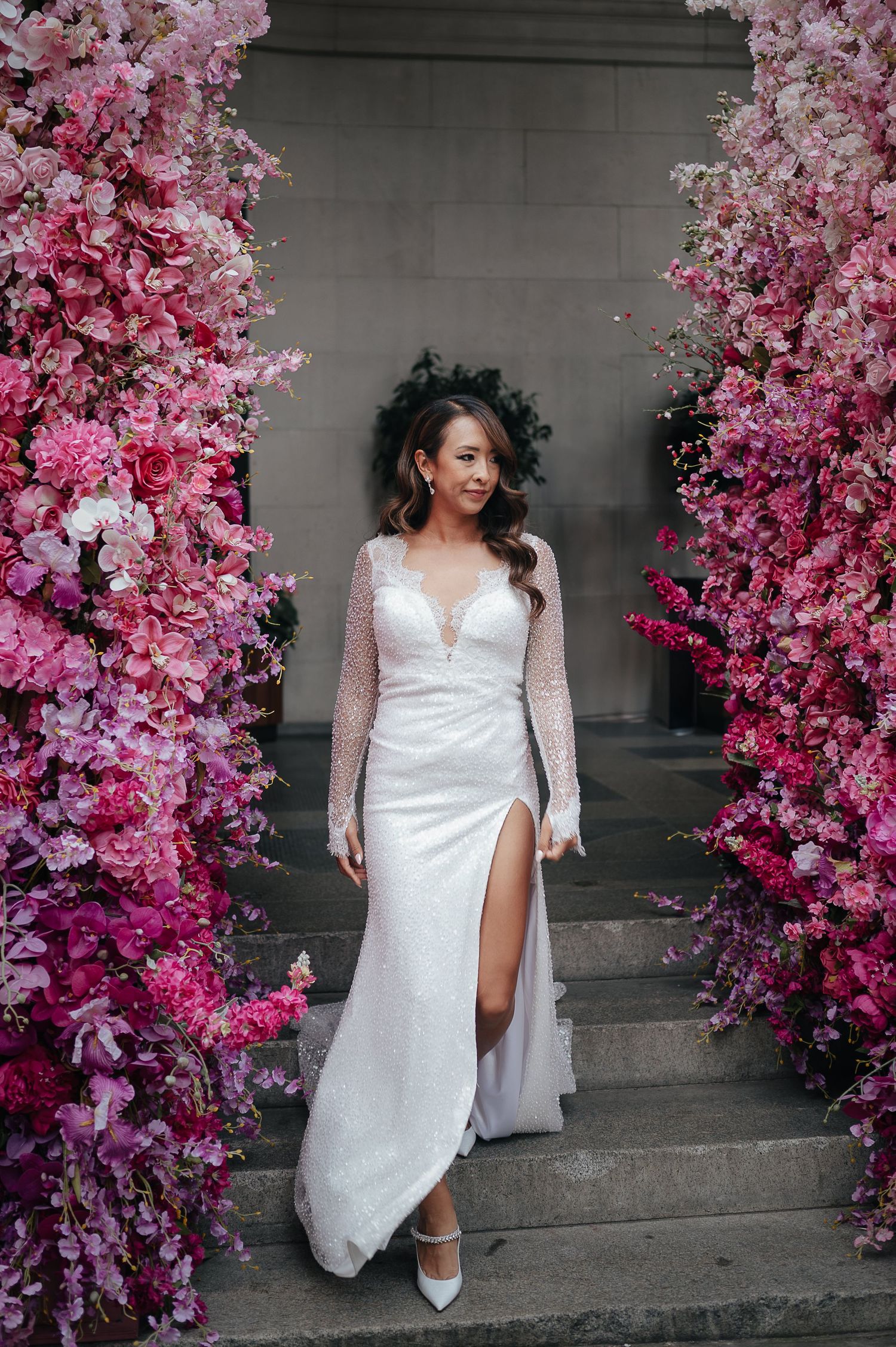 Stunning bridal portrait with white gown framed by pink cherry blossoms.