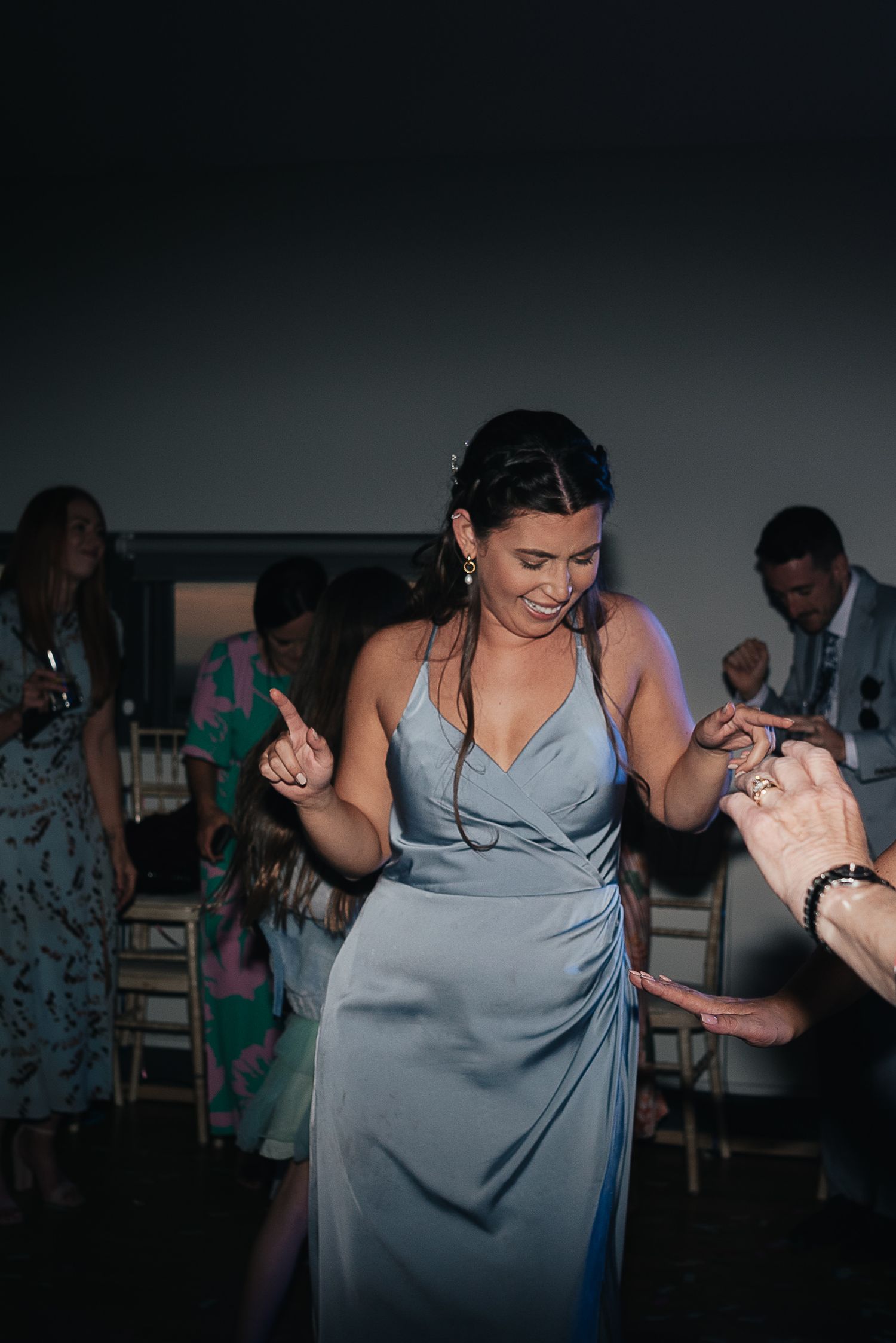A bridesmaid in pale blue dress dances at wedding reception.