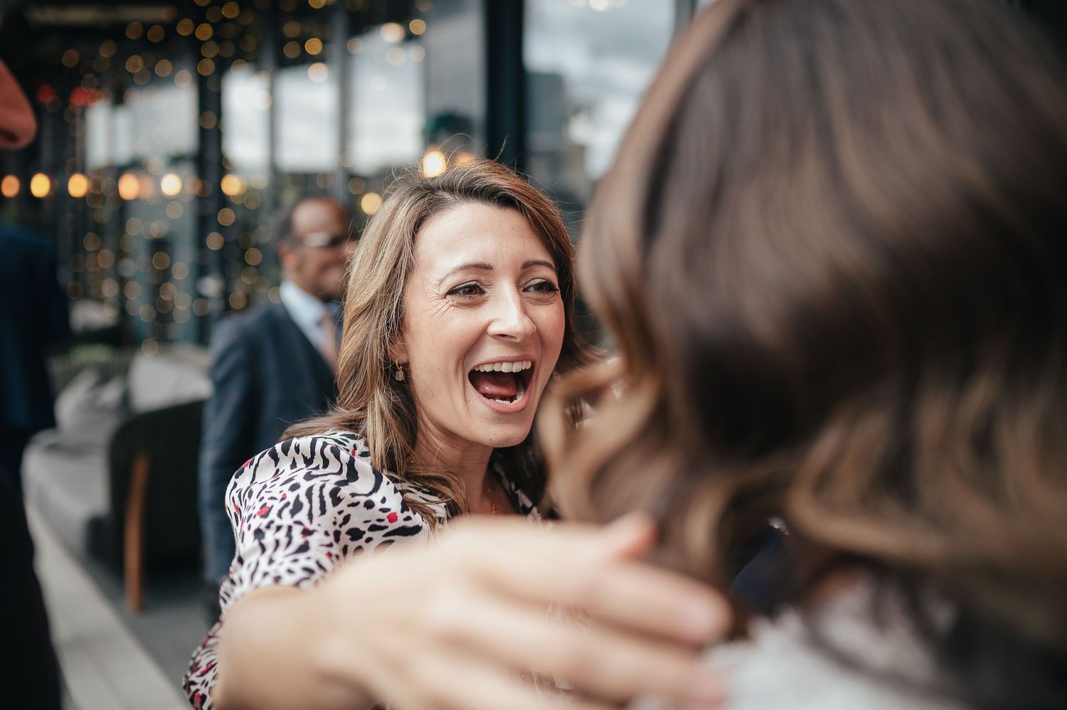 Candid moment of joyful laughter during wedding celebration.