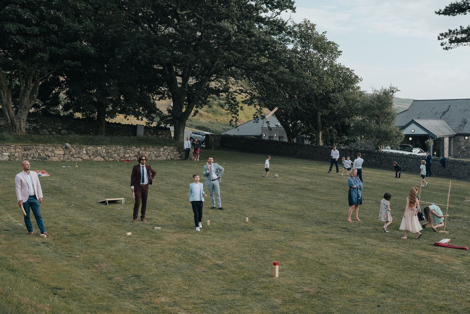 Wedding guests playing lawn games at an outdoor reception.