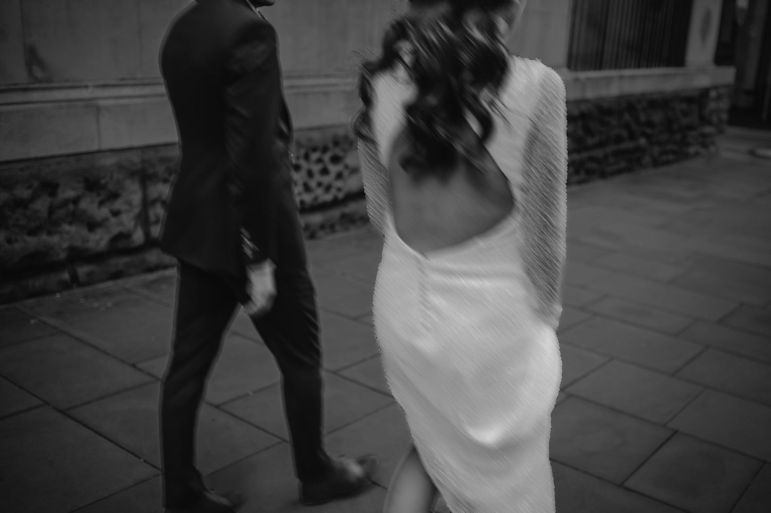 Artistic black and white shot of couple walking together on wedding day.