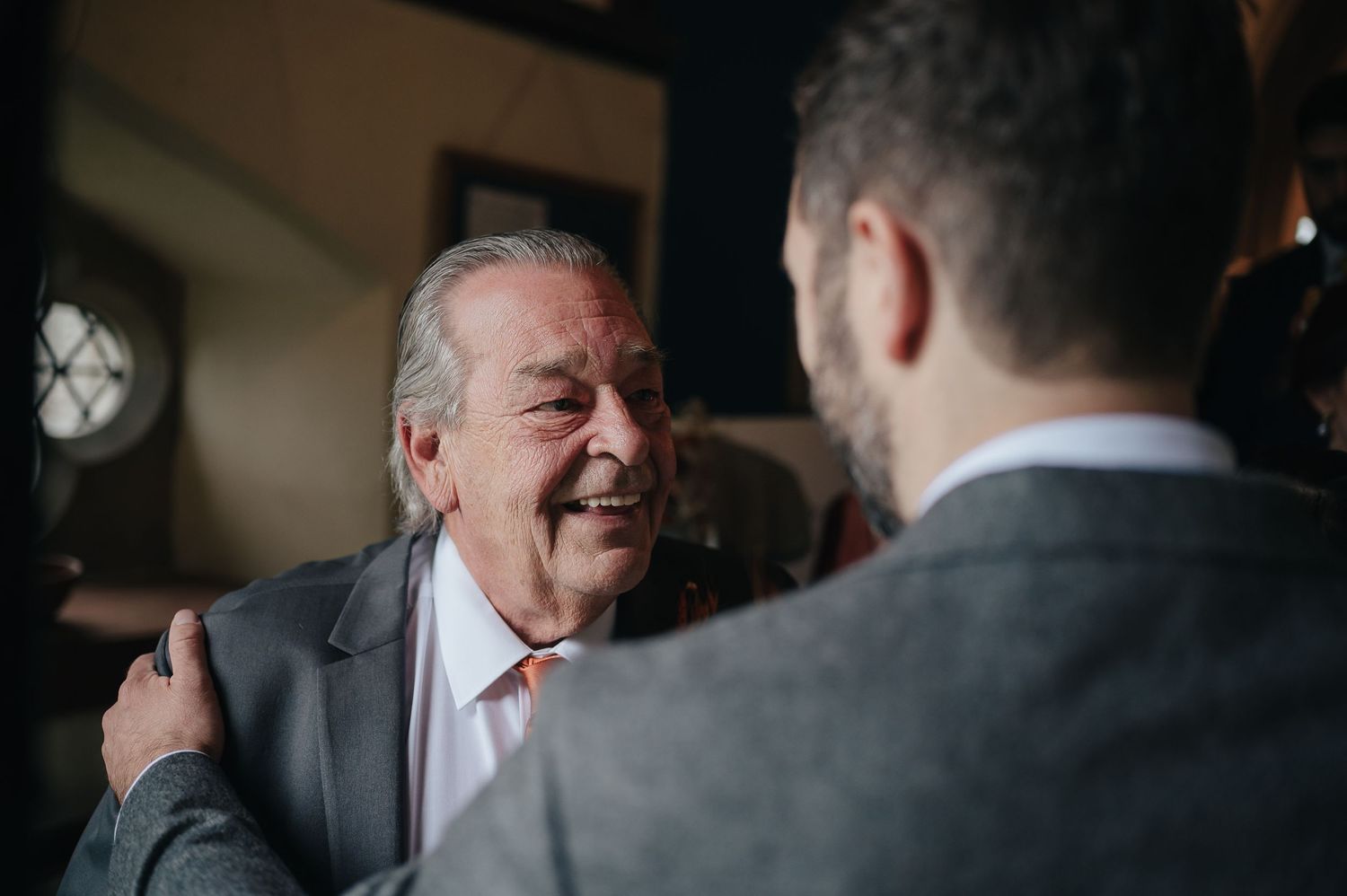 An emotional candid moment shared between two guests at a wedding reception.